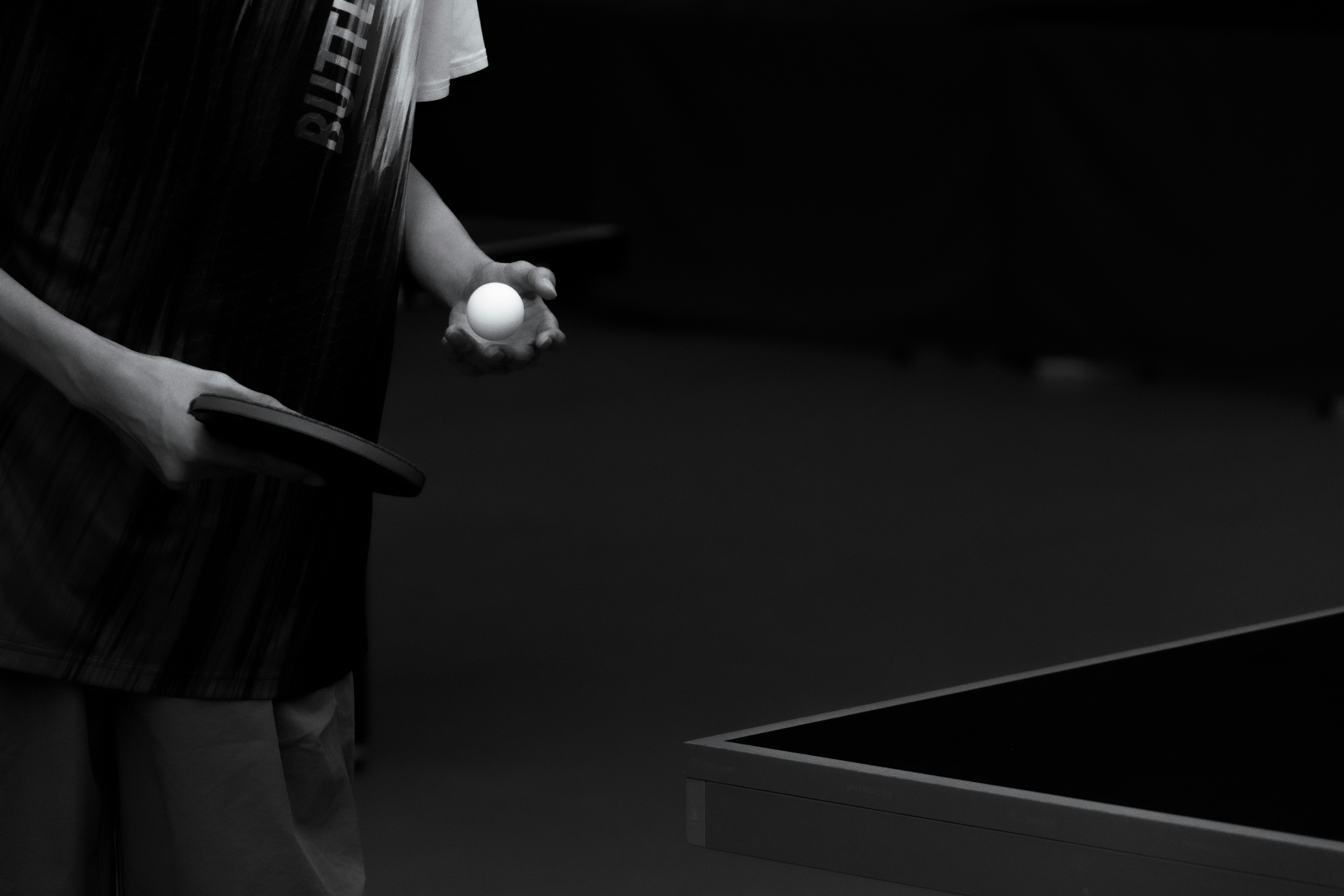 Person holding ping pong paddle and ball