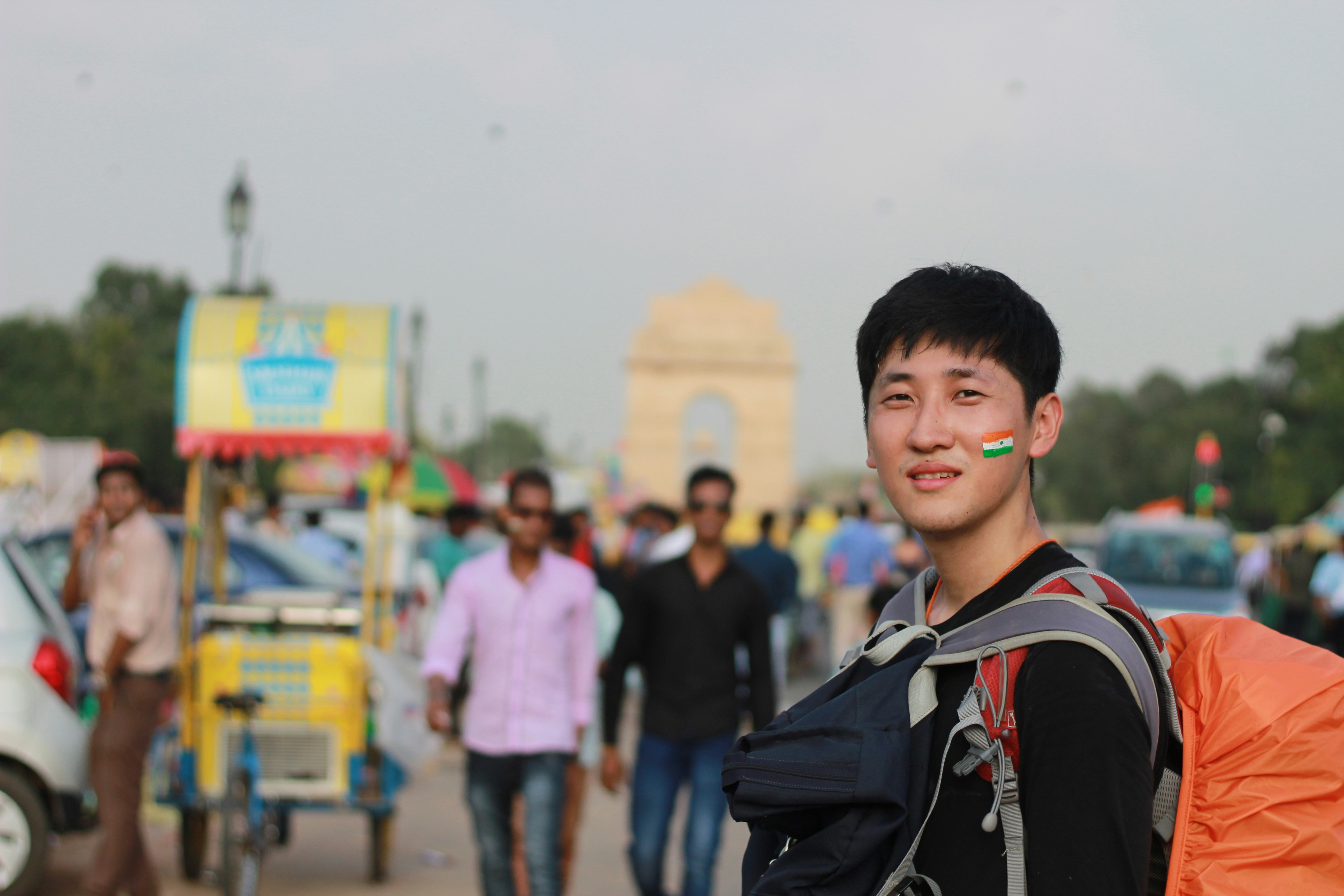 Man with indian flag painted on cheek in busy street