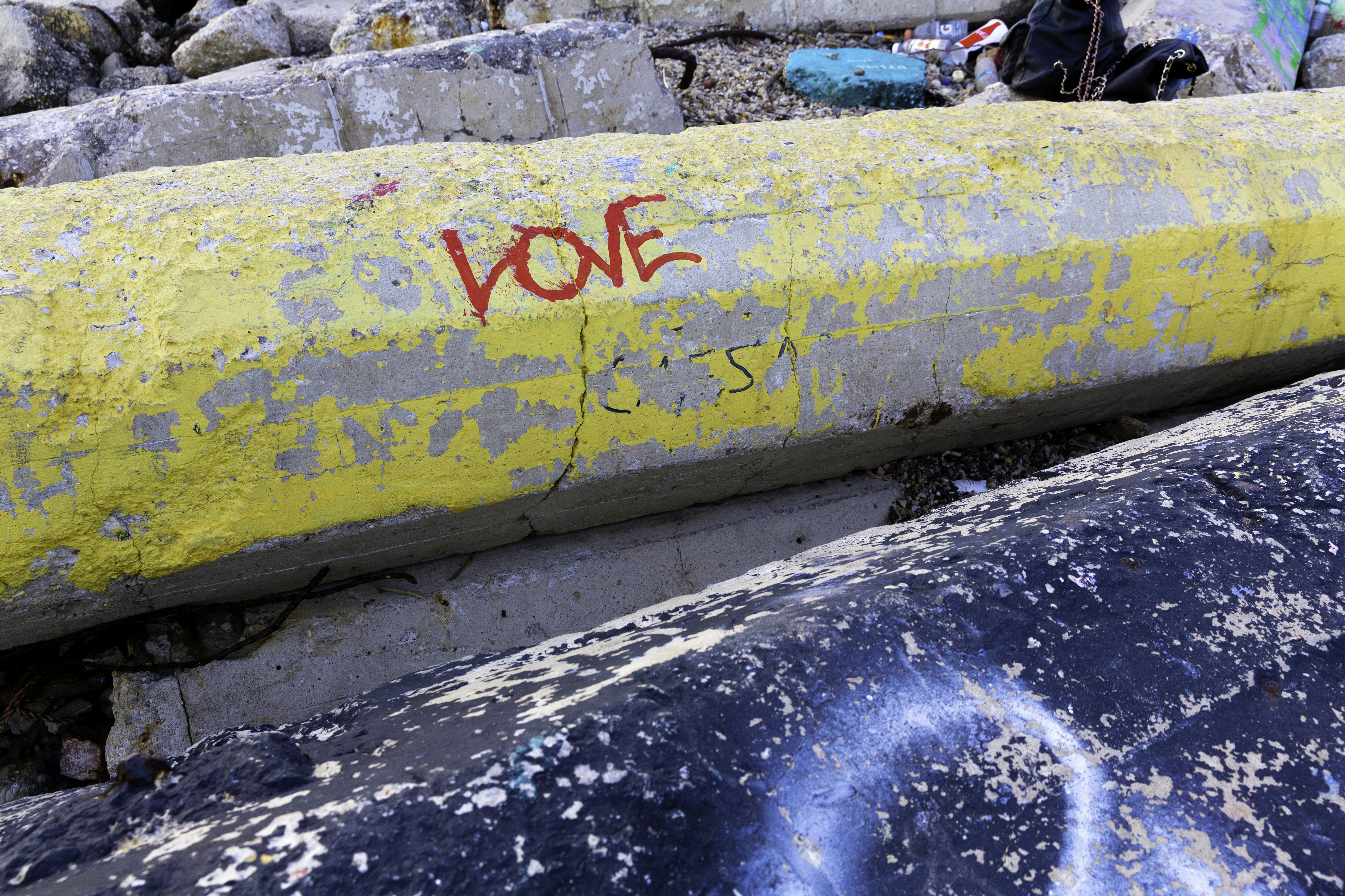 Palabra roja grafiti de amor en la barrera amarilla de hormigón