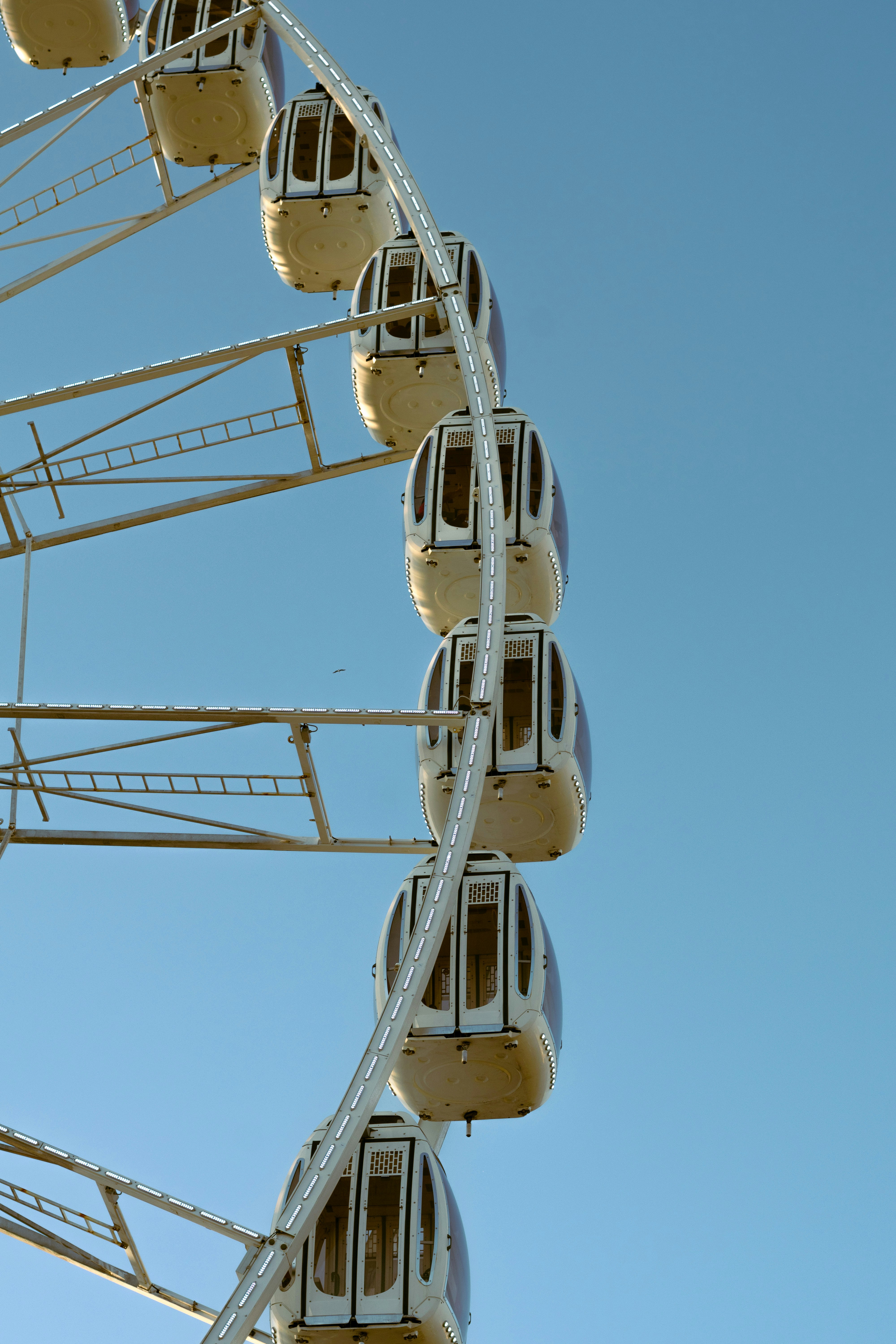 Ferris wheel cabins against a clear blue sky