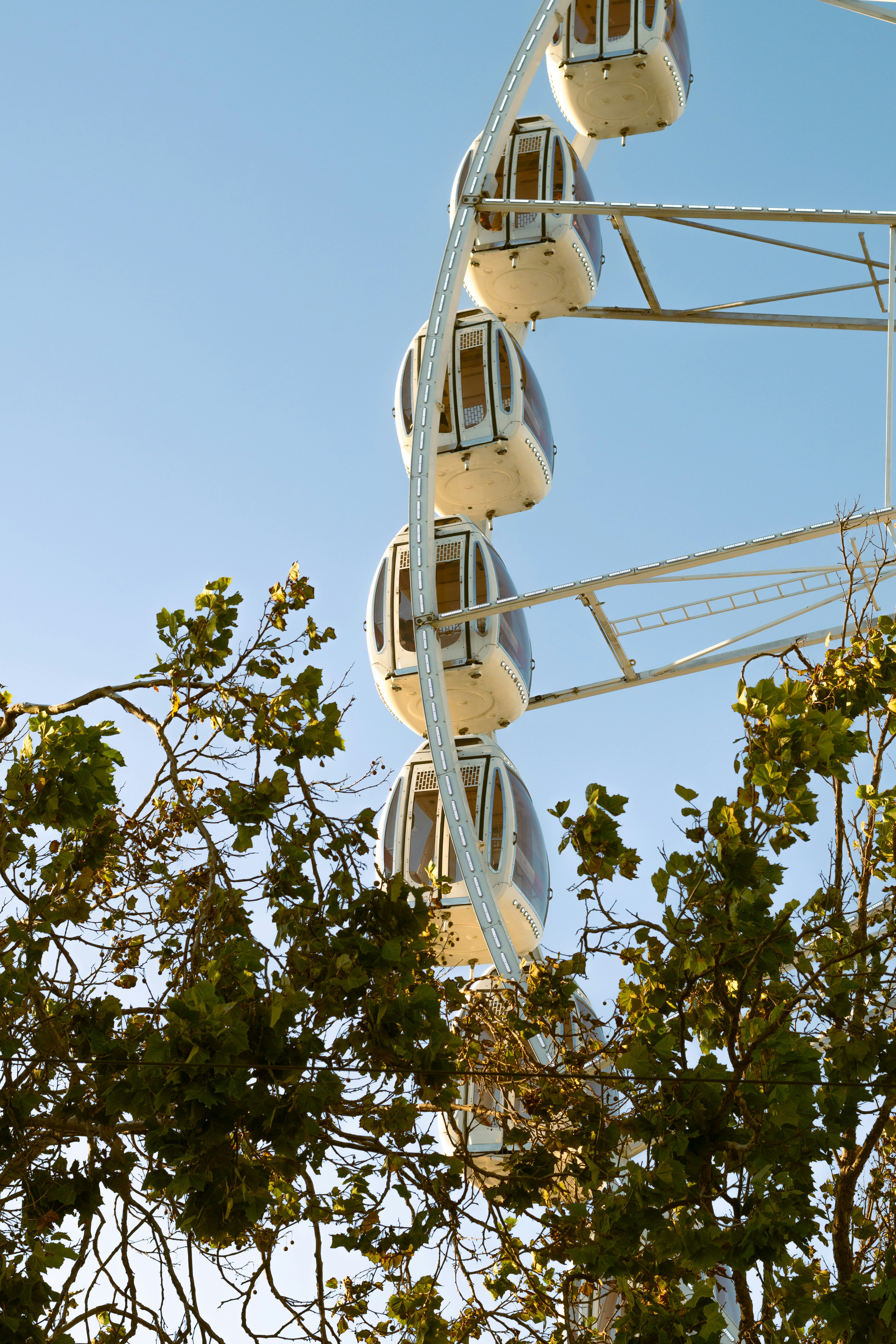 Ferris wheel gondolas against a clear blue sky.