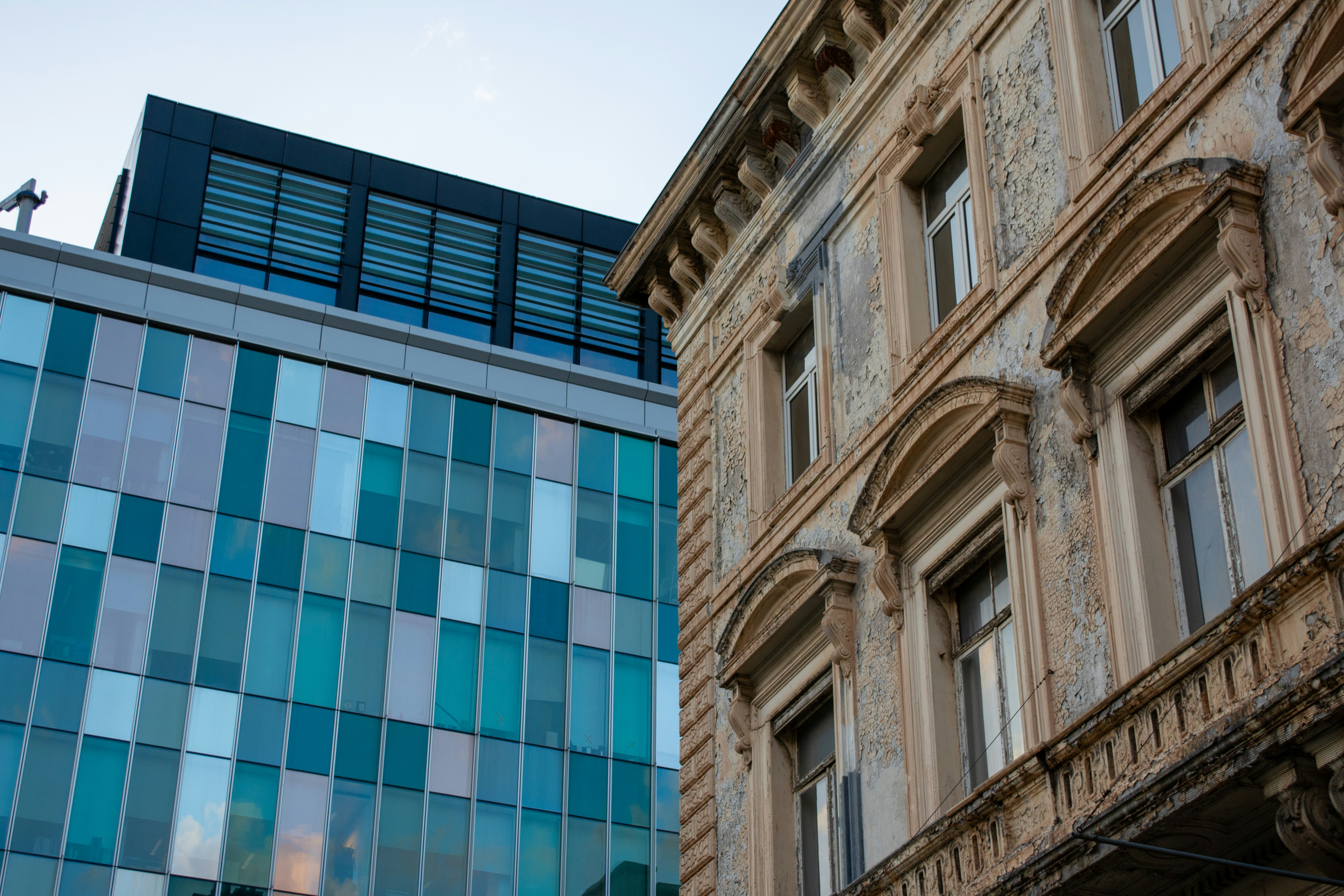 Construcción moderna en contraste con arquitectura antigua y ornamentada