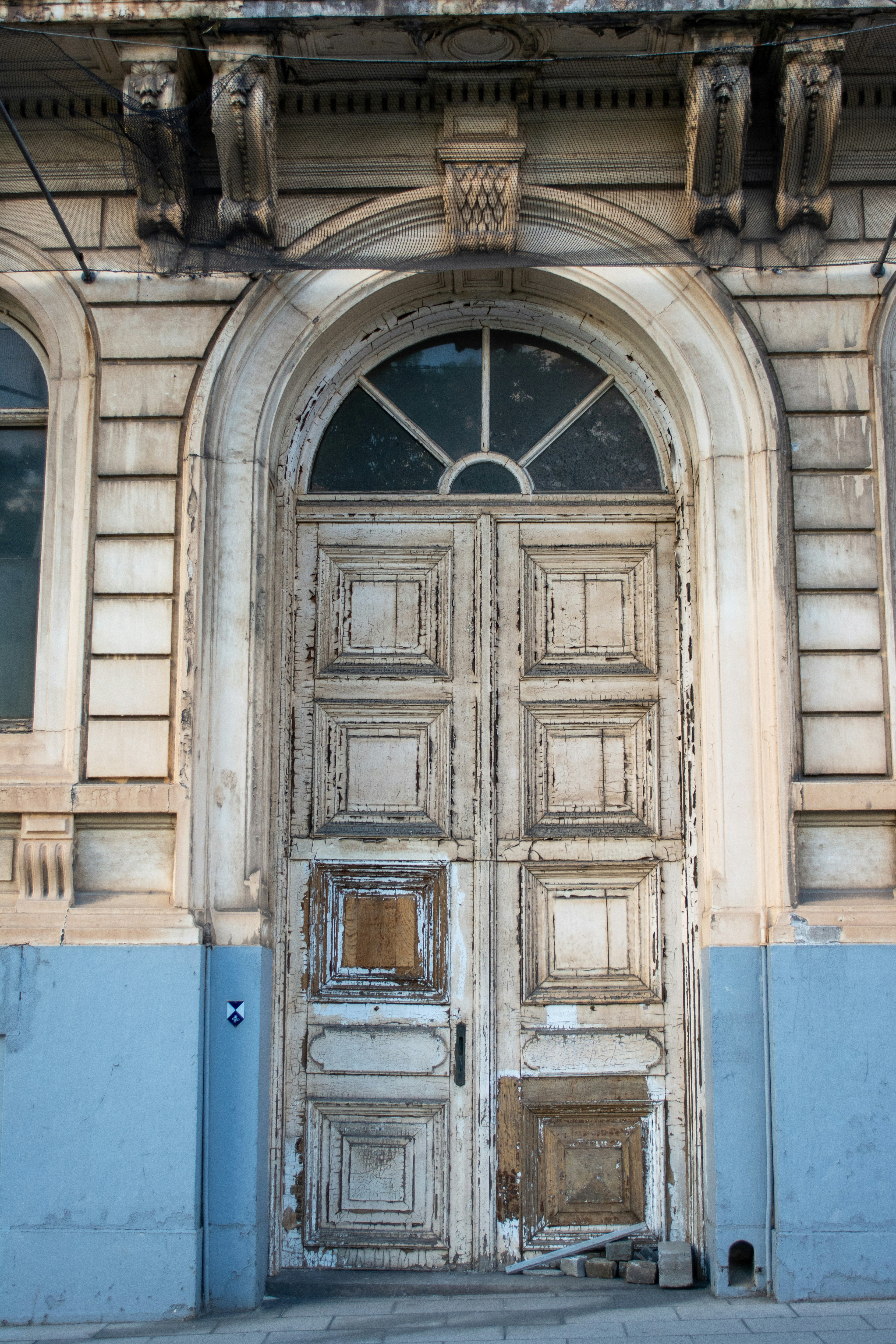 Una vieja puerta de madera desgastada con ventana arqueada.