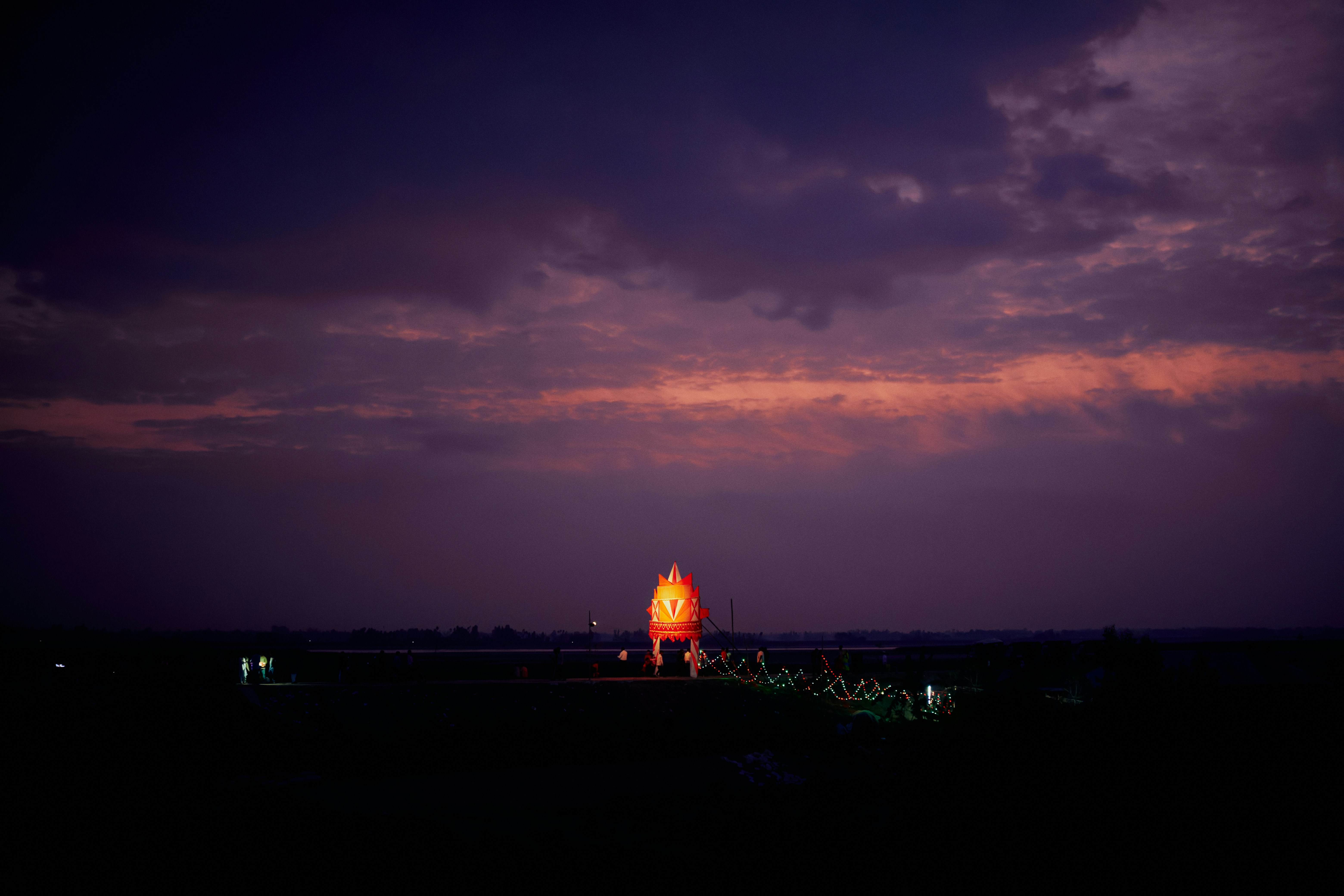 Hot air balloon illuminated against a dramatic twilight sky
