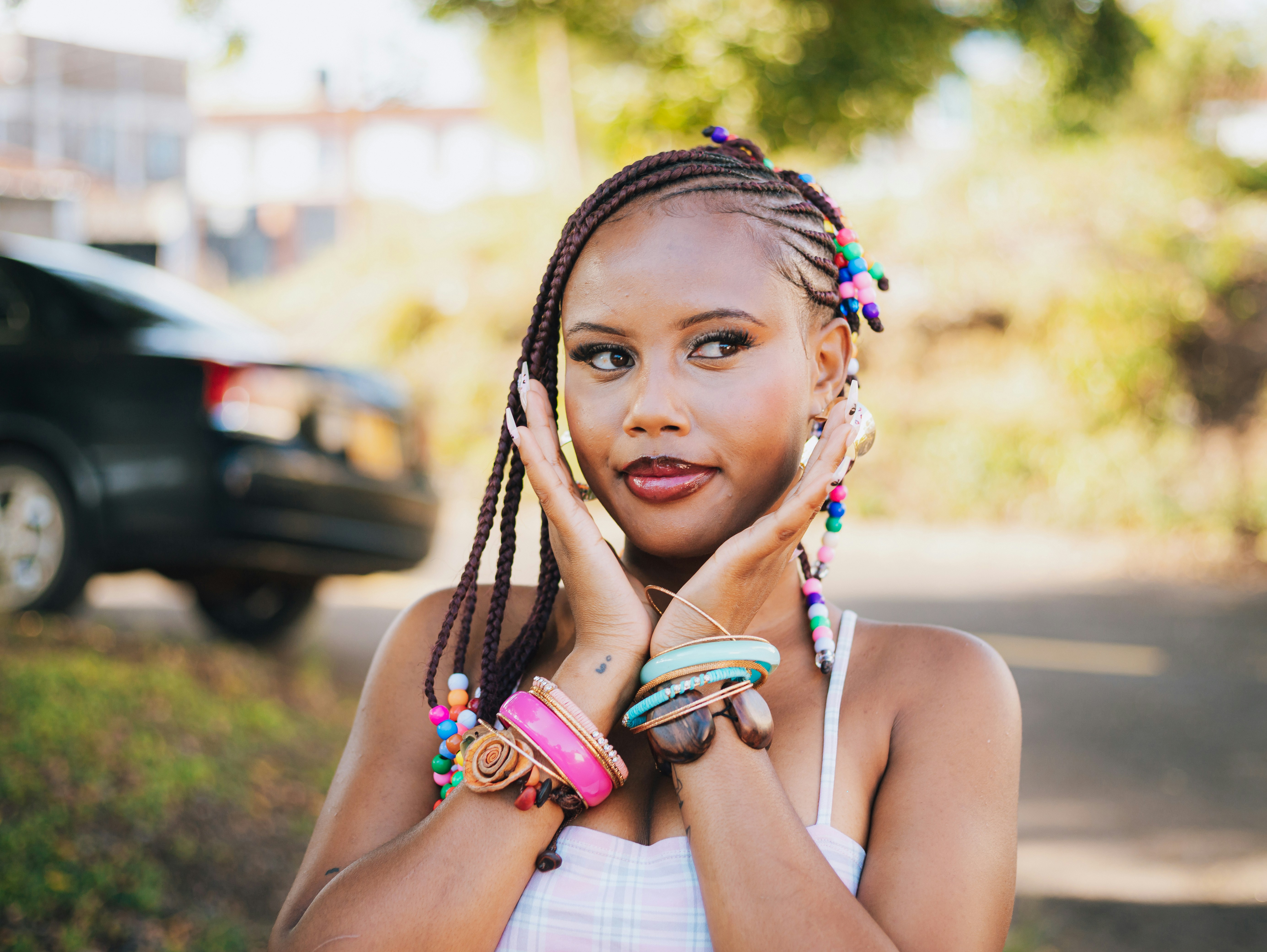 Young woman with braided hair and colorful beads.