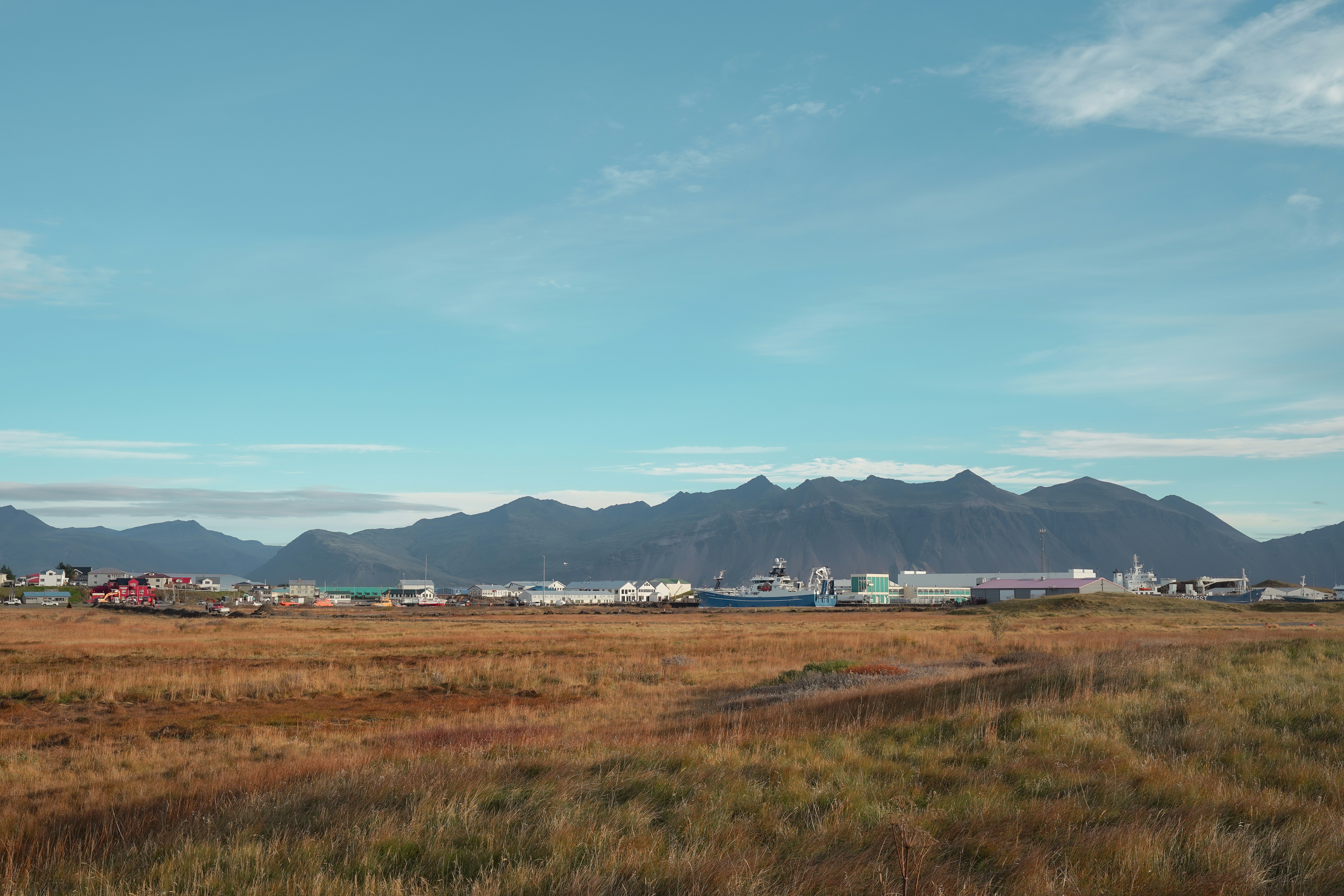 Town nestled against a mountain range under a blue sky.