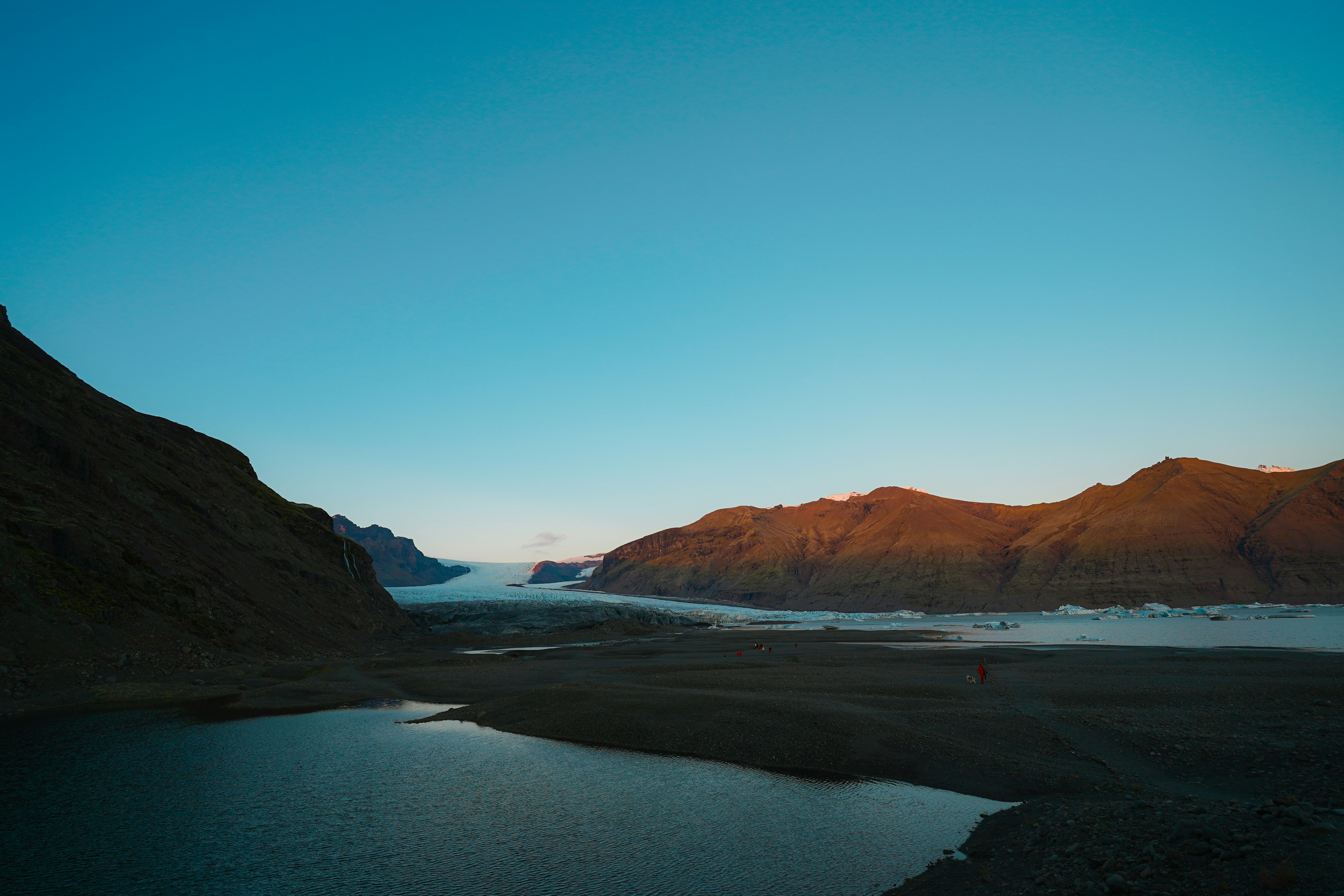 Mountain landscape with a lake and glacier at sunset