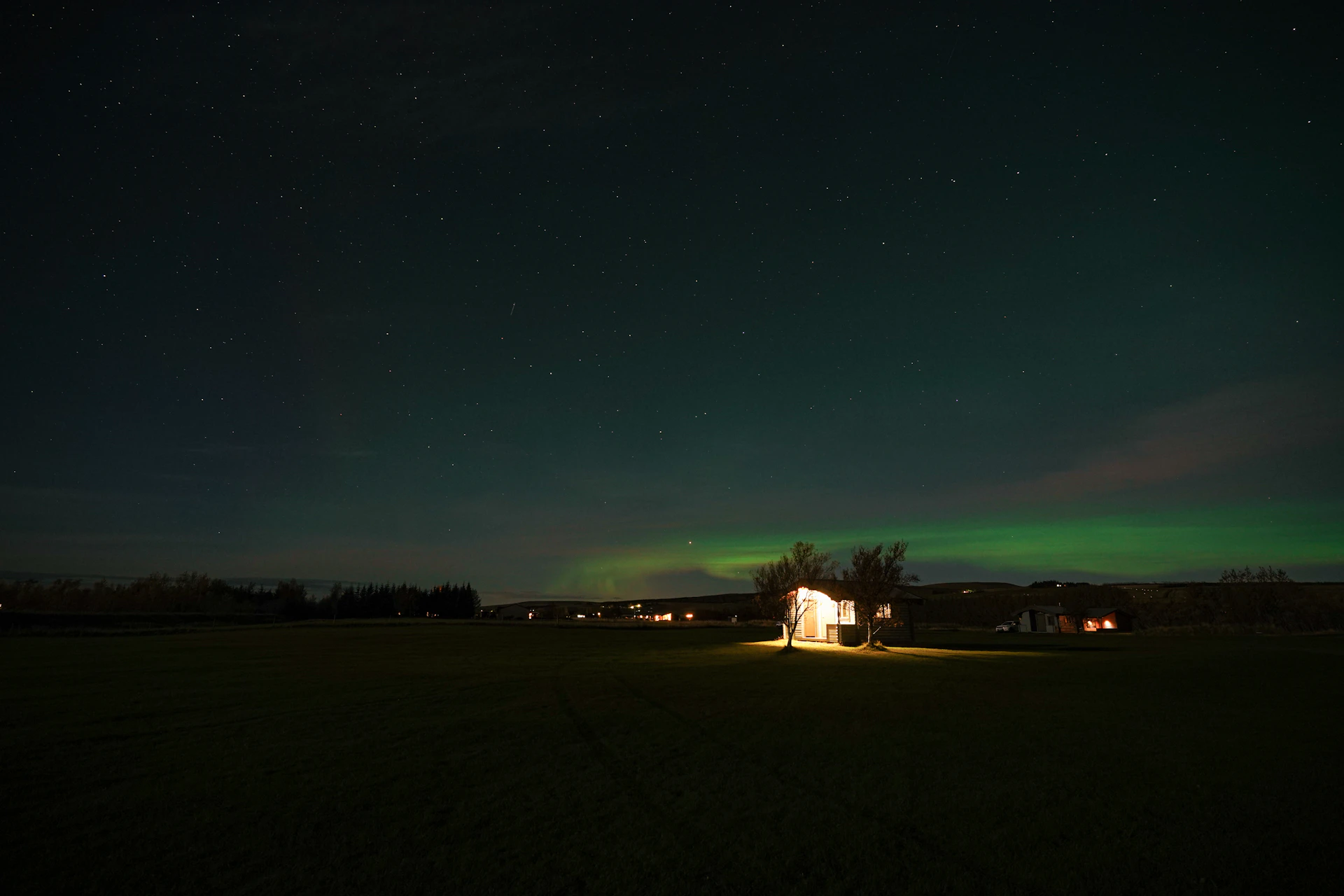 Aurora borealis over a rural landscape at night