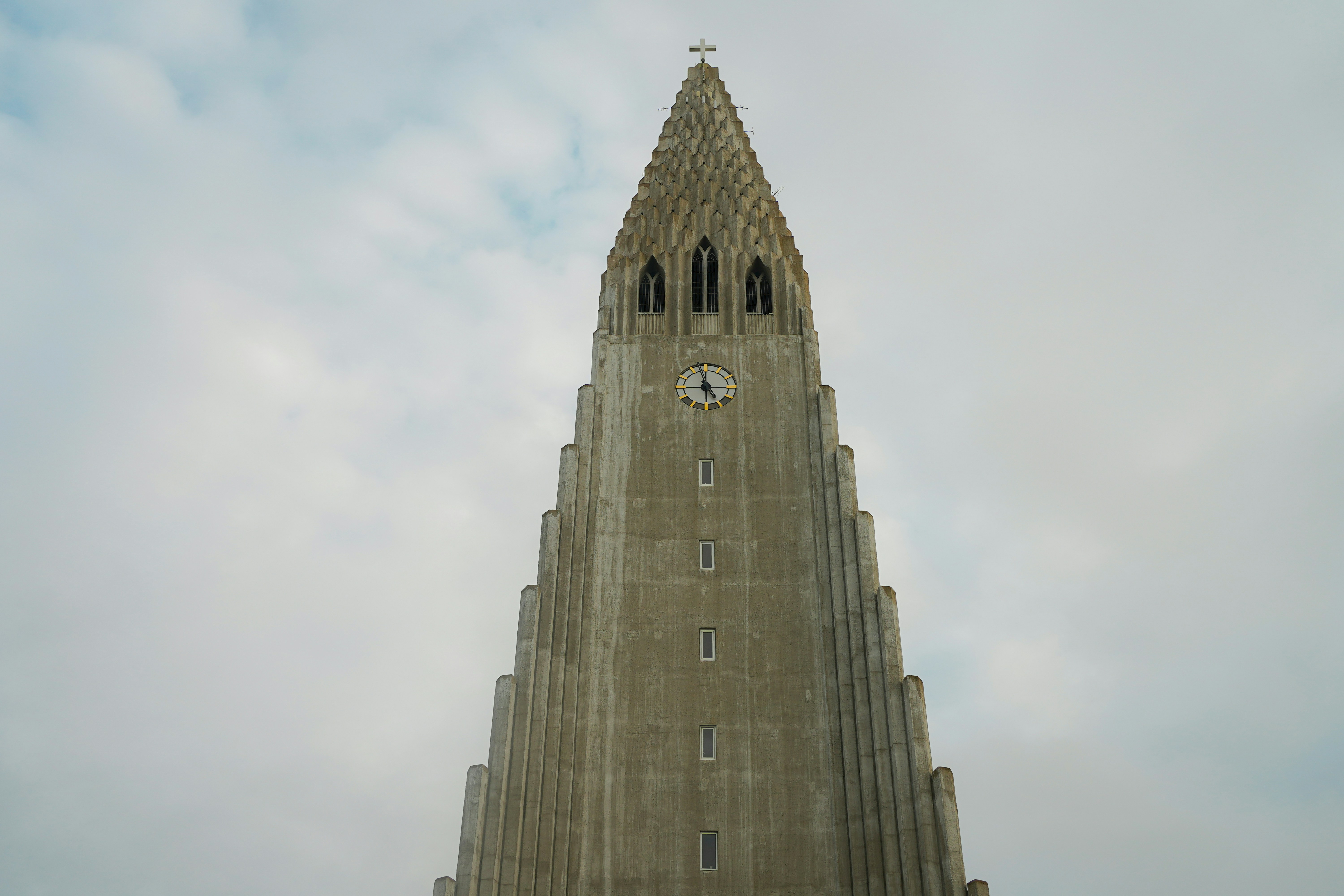 Tall concrete church tower against a cloudy sky