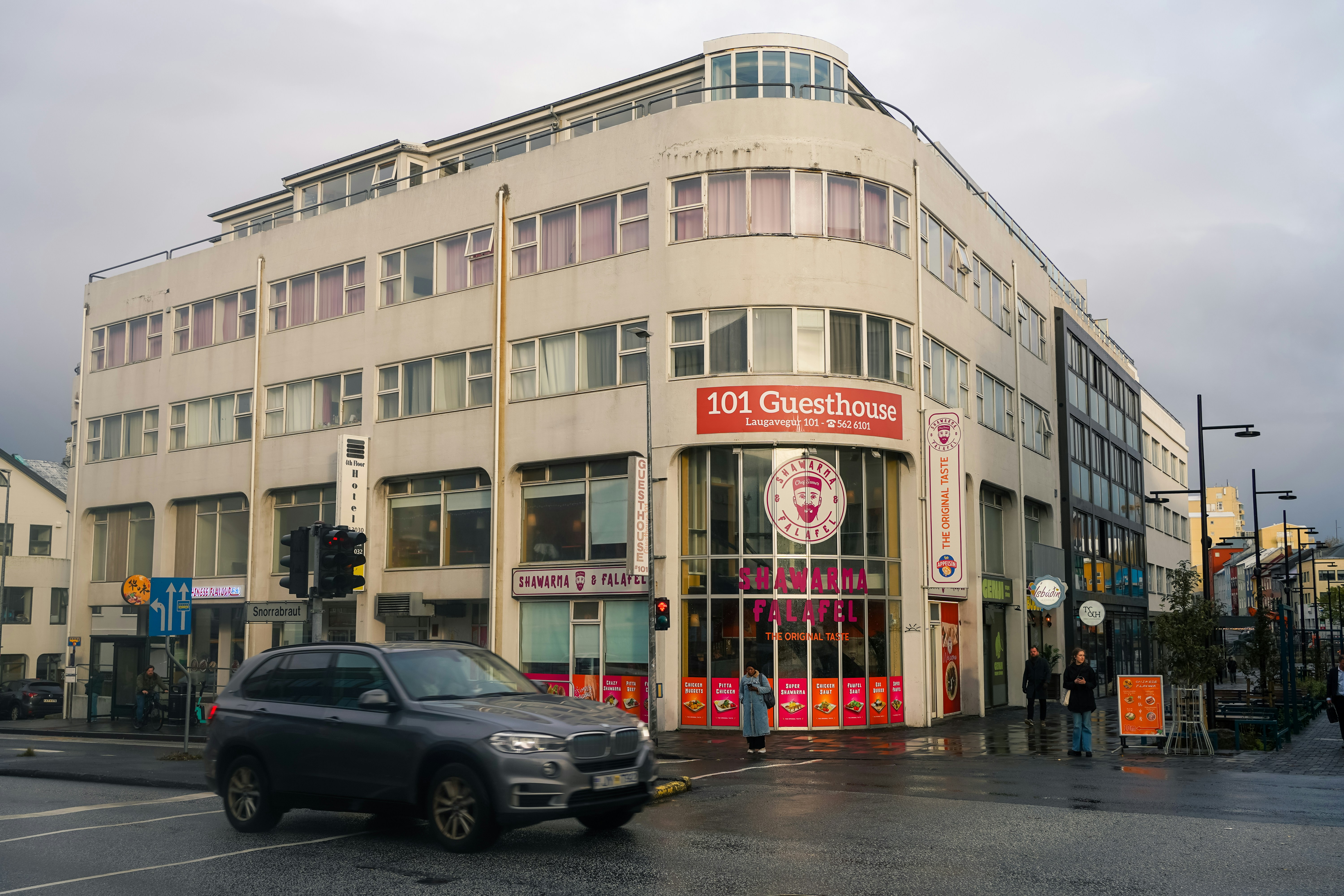 Modern building with "101 guesthouse" sign on street.