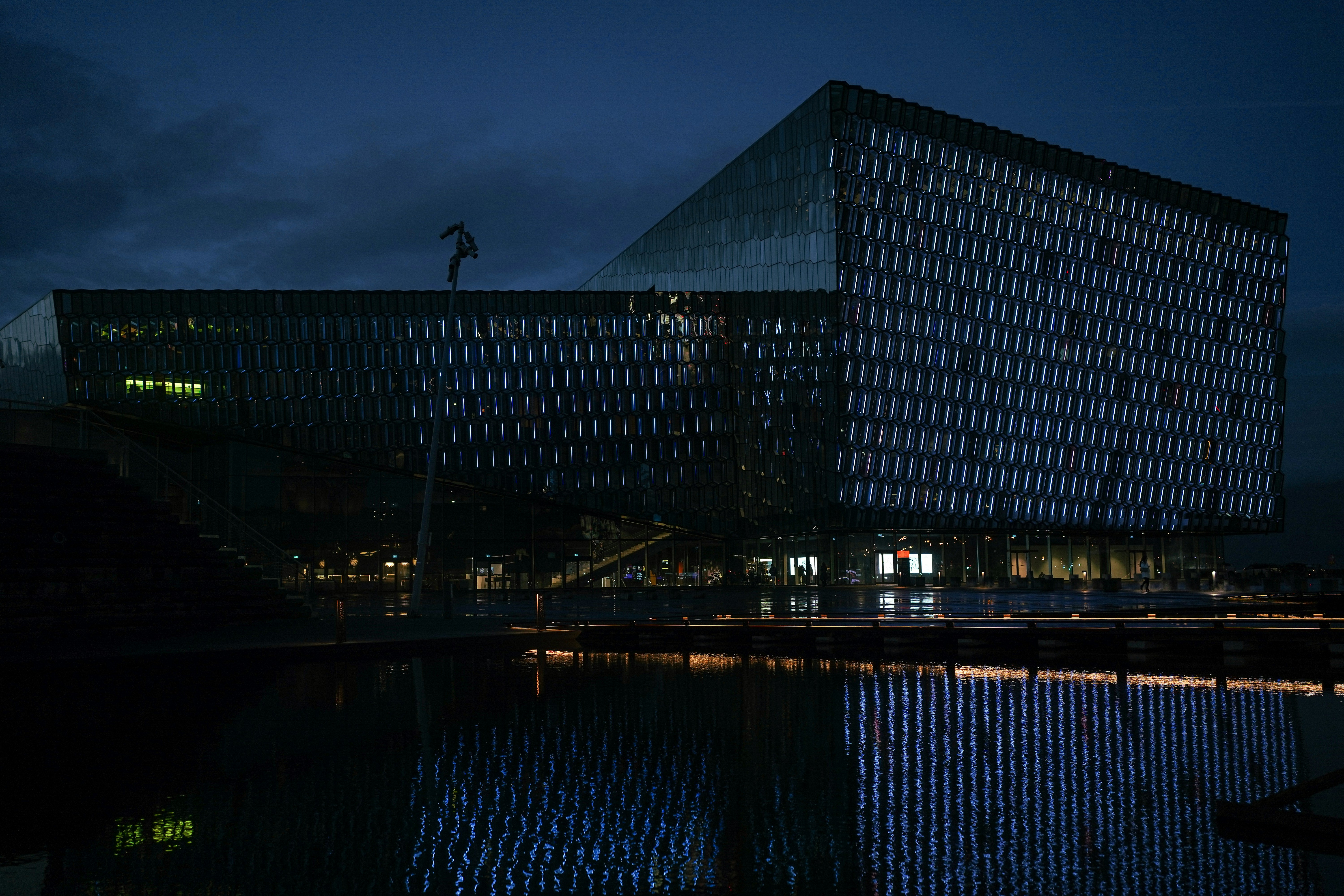 Modern glass building illuminated at night with reflections