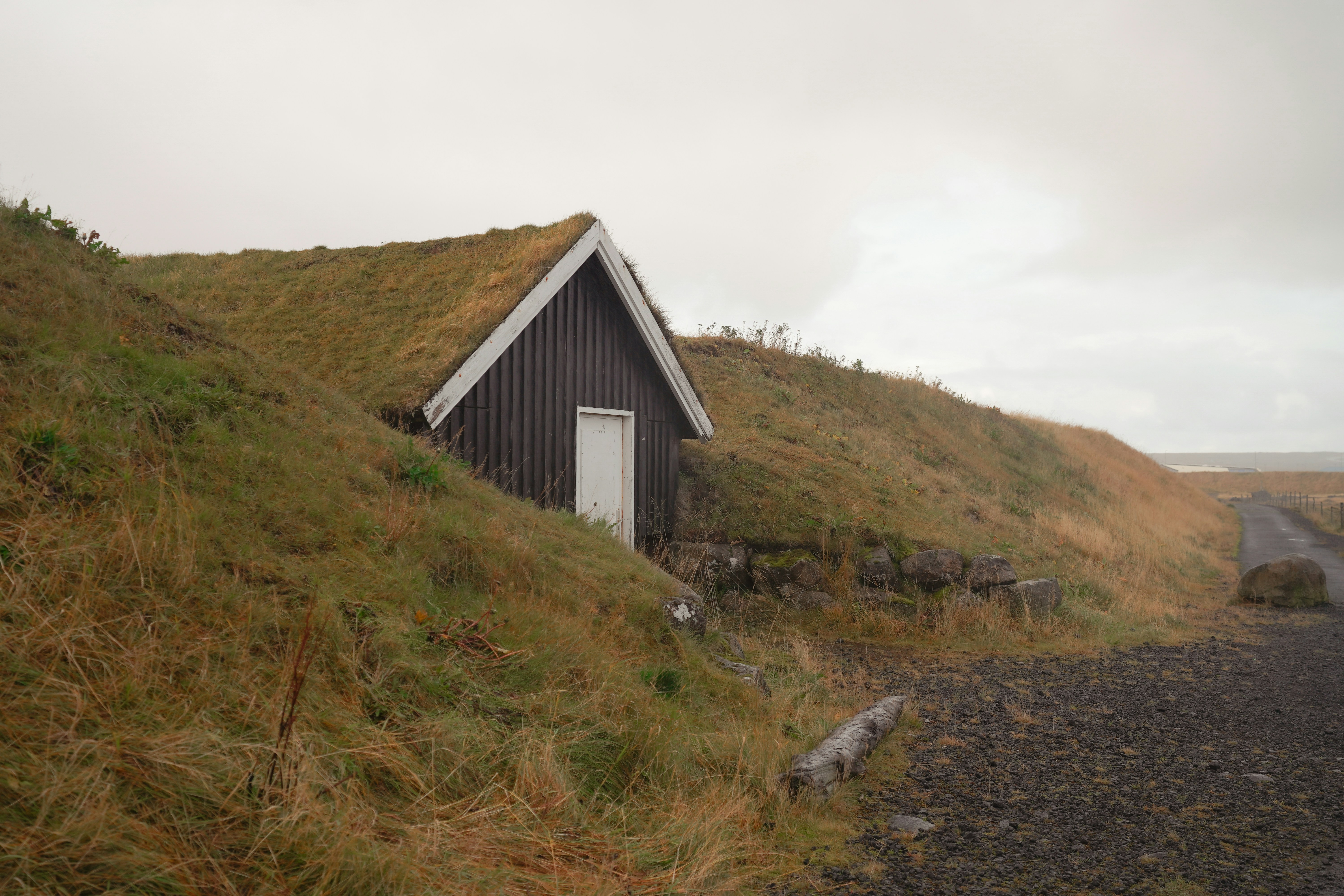 A turf-roofed house built into a grassy hillside.