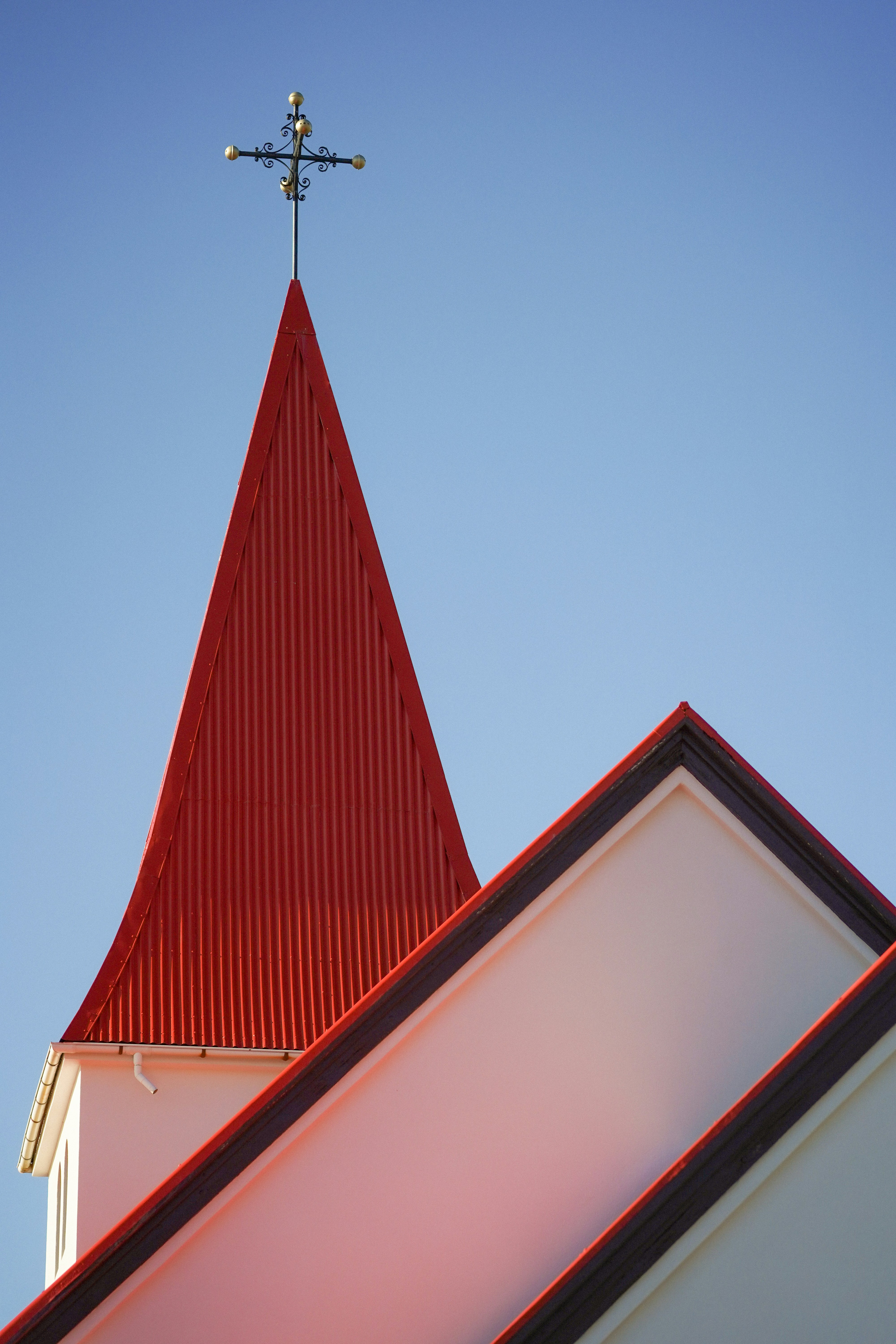 Red church steeple against a clear blue sky
