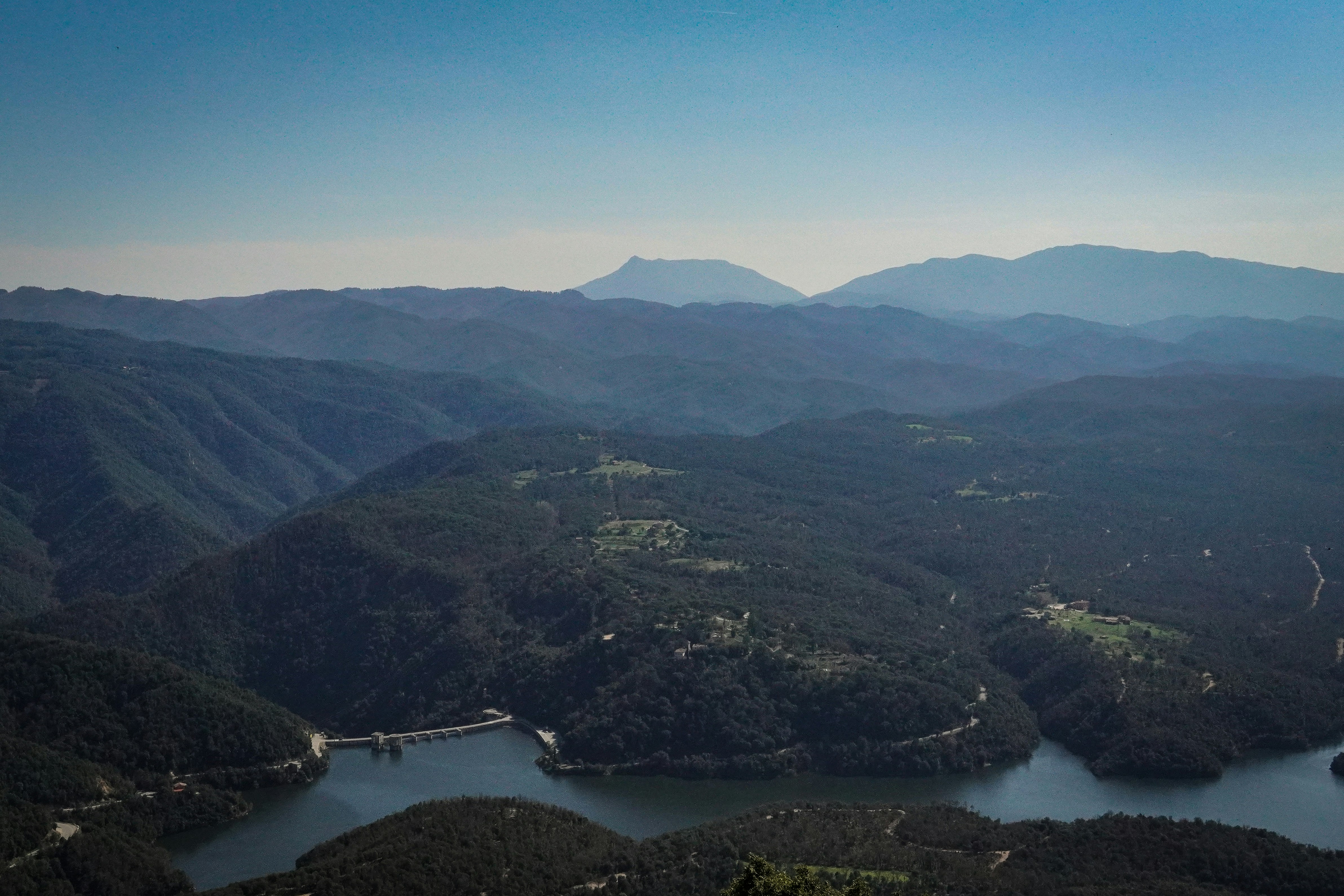 A serene mountain landscape with a lake and dam.
