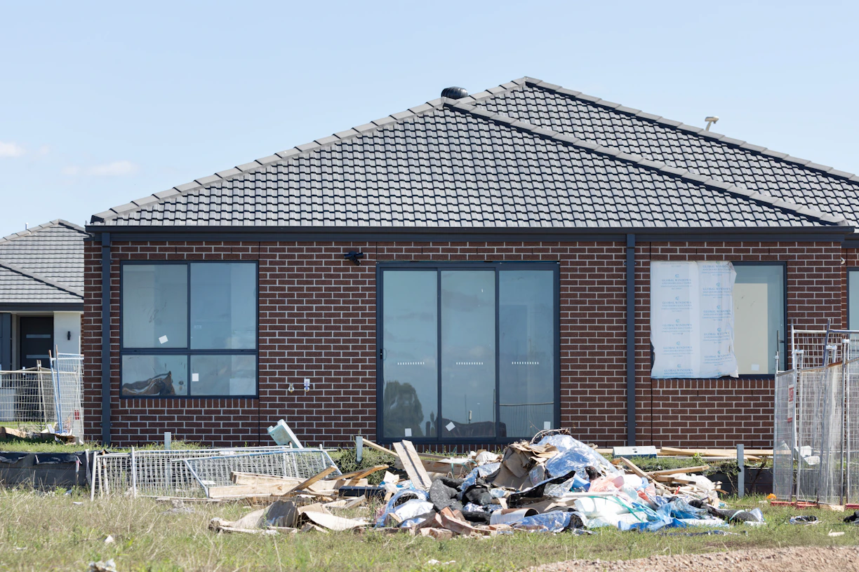 Construction debris piled in front of a brick house In Sydney 