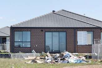 Construction debris piled in front of a brick house In Sydney 