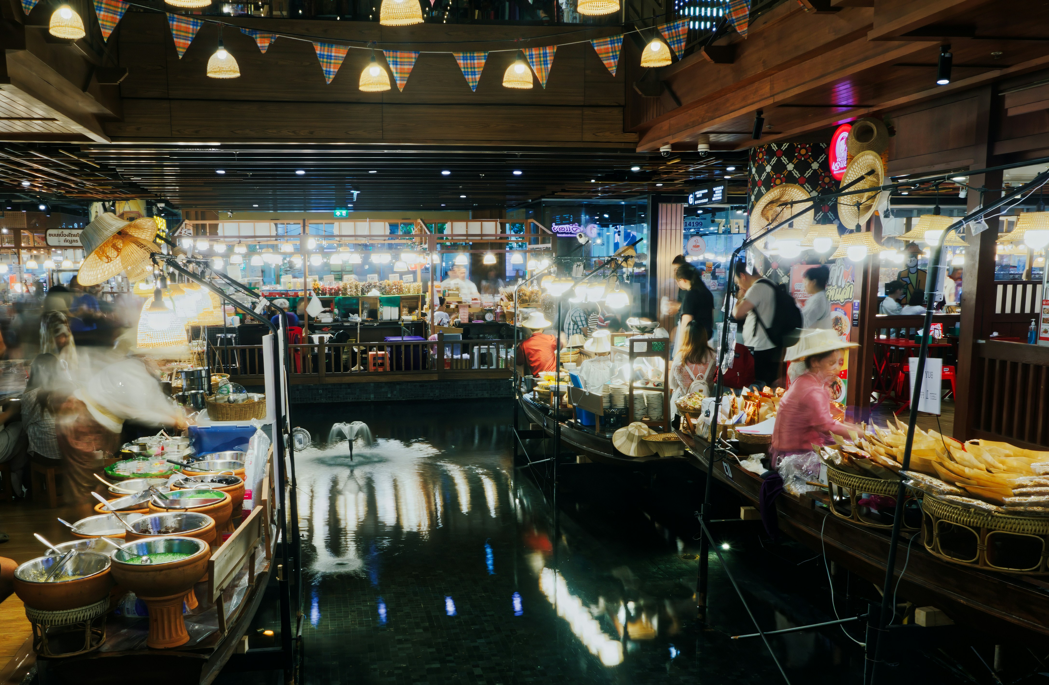 夜の賑やかな浮き市場で買い物をする人々。