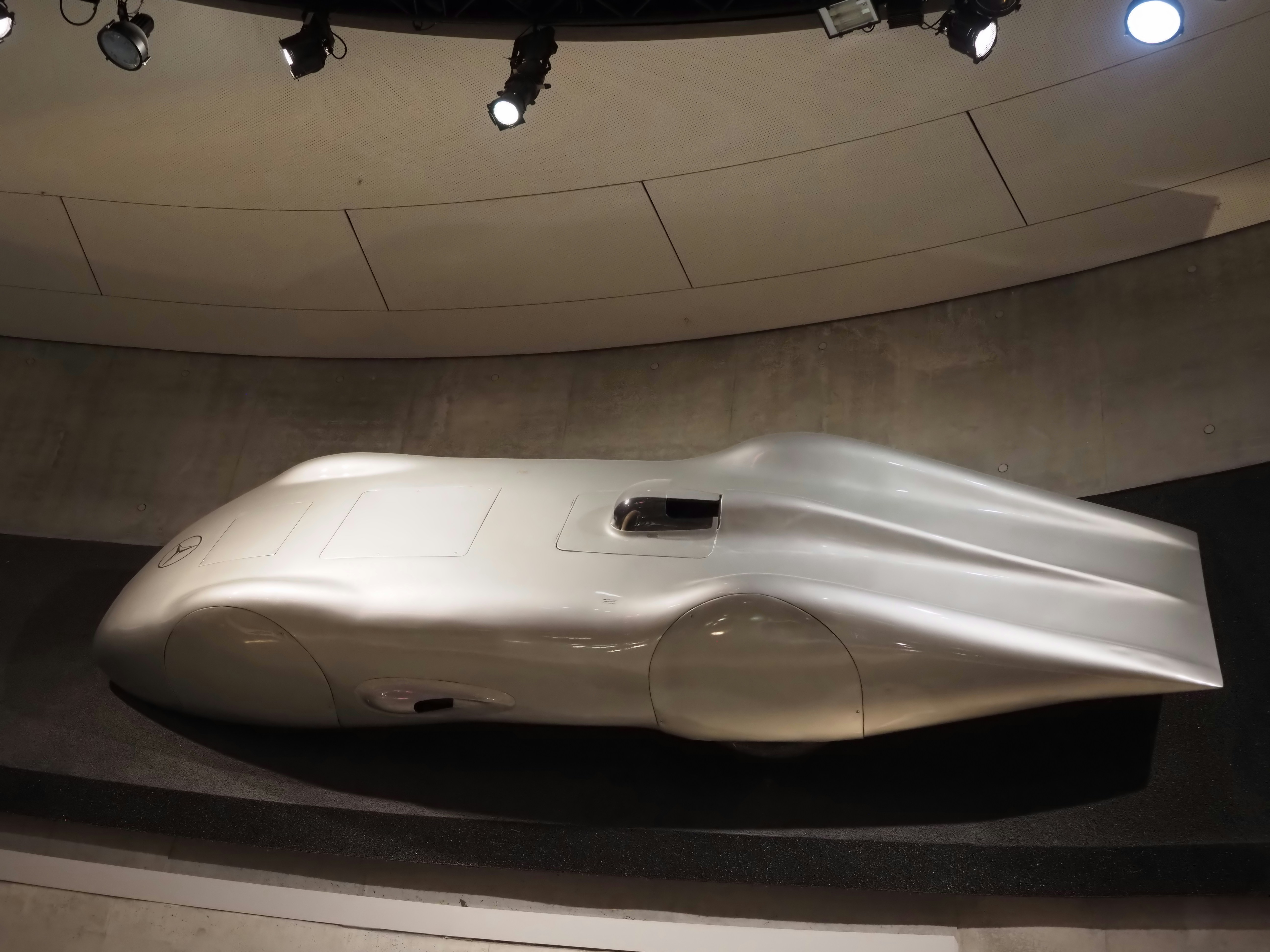 Um carro streamliner vintage prateado em exibição
