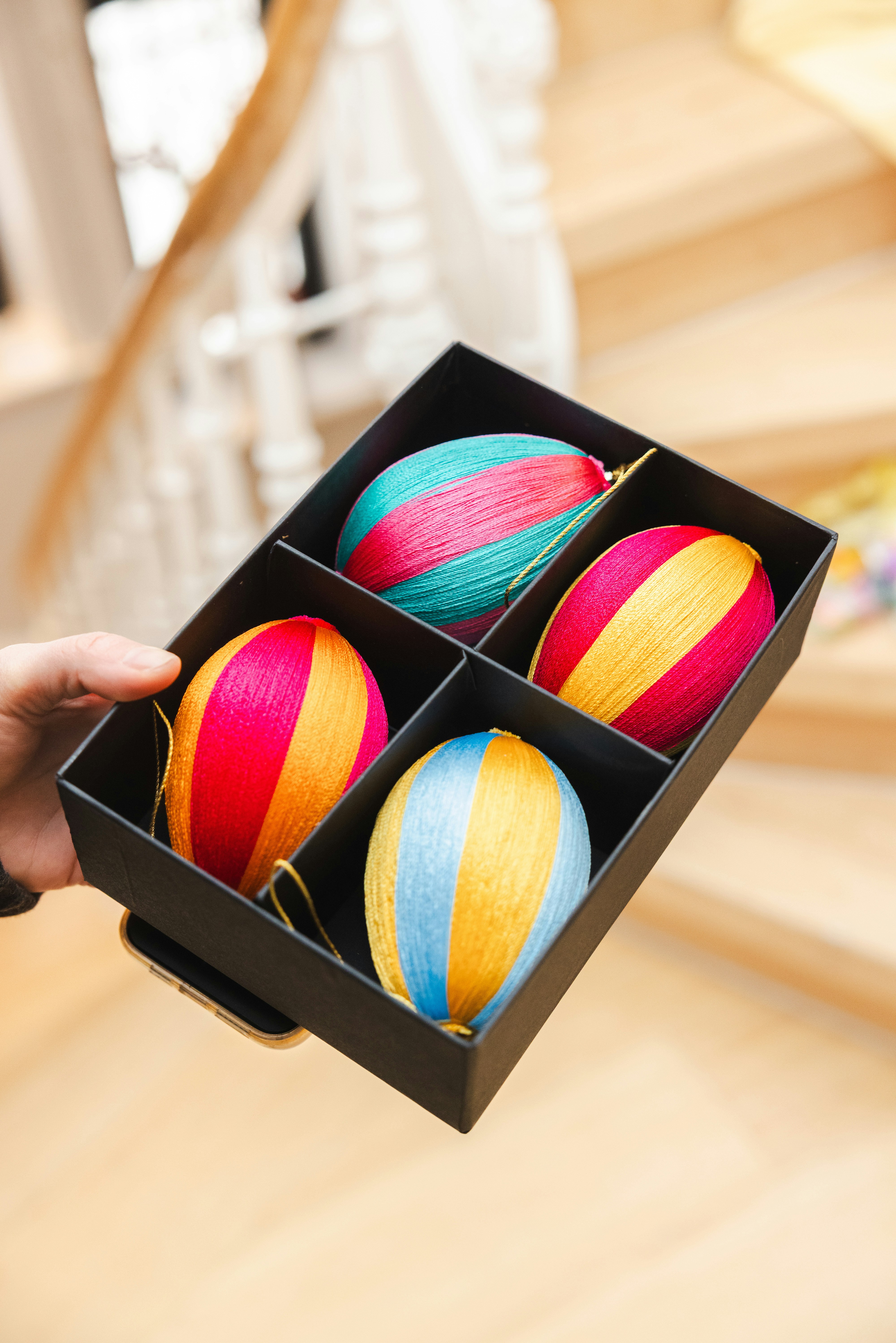 Quattro uova di Pasqua colorate a righe in una scatola nera