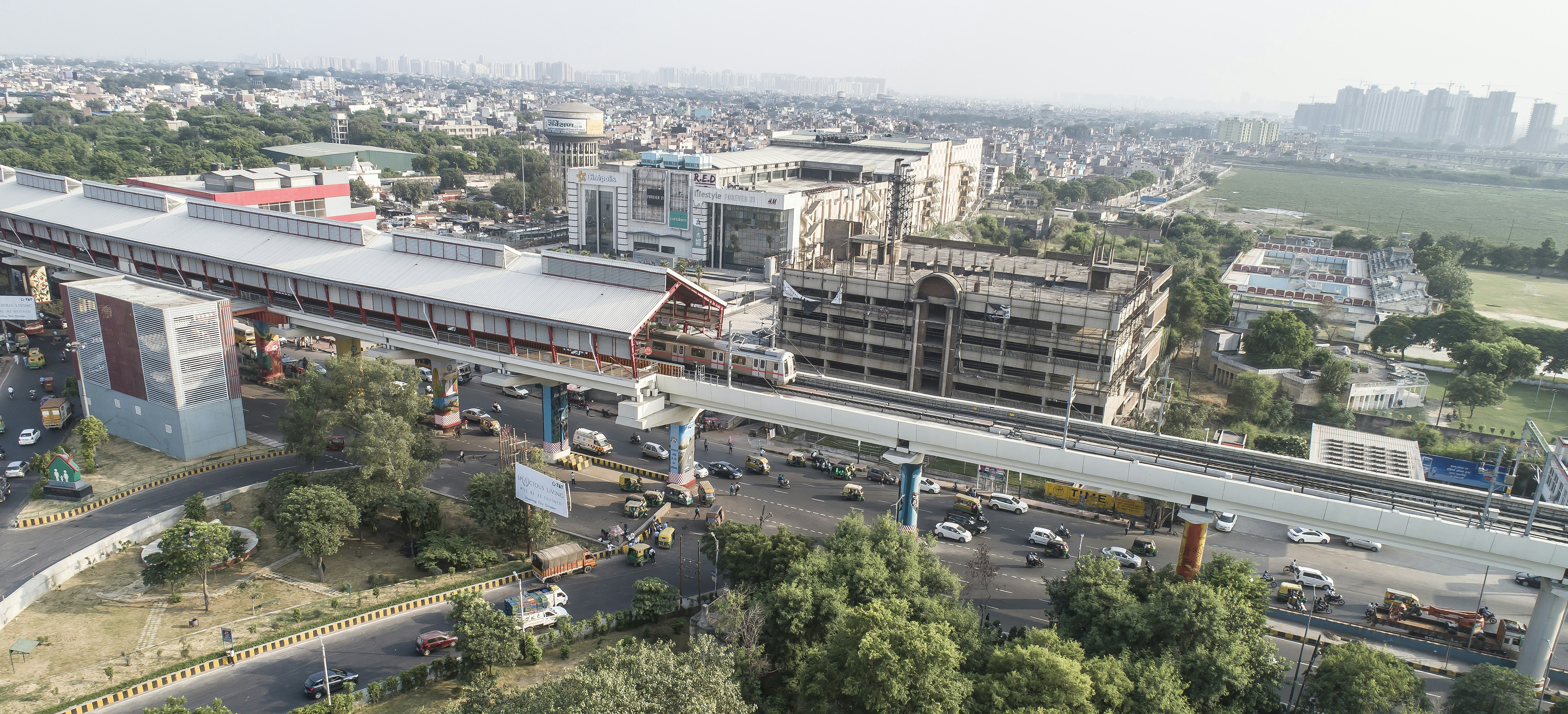 Un treno sopraelevato della metropolitana passa vicino a una moderna stazione cittadina.