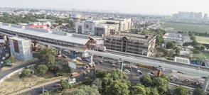 Elevated metro train passes by a modern city station