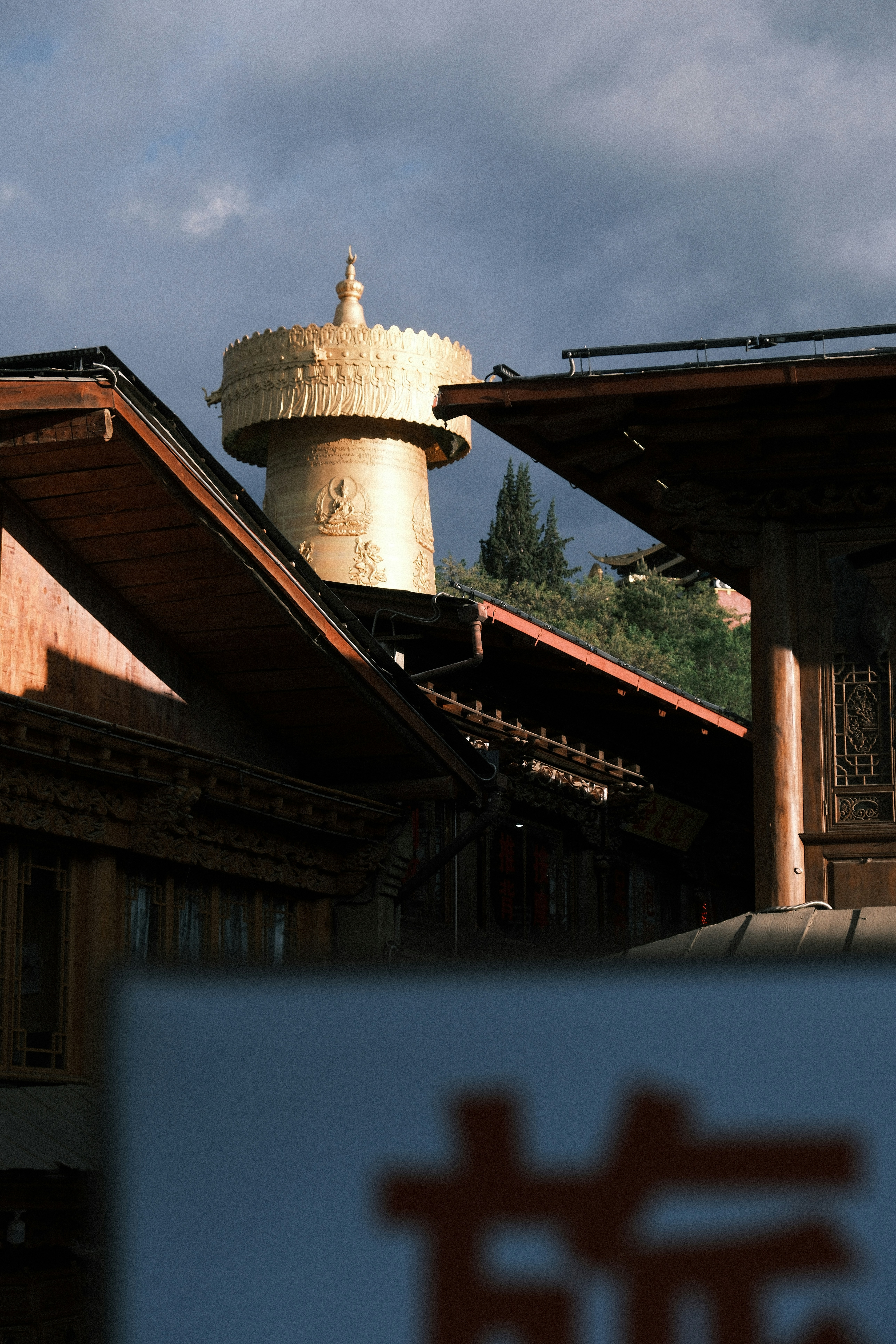 Stupa dorato in cima a una collina dietro edifici di legno