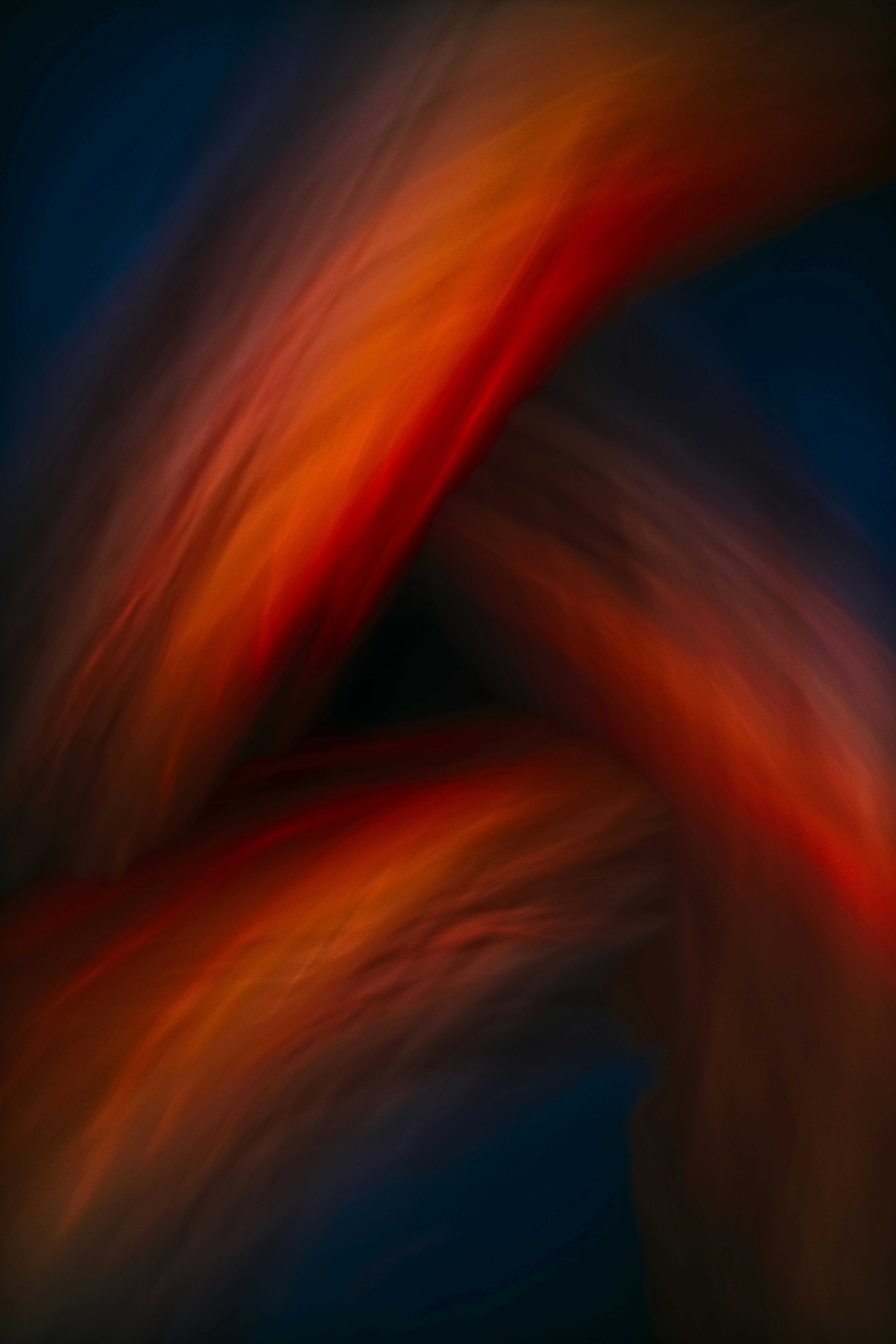 Abstract swirl of orange and red on dark blue