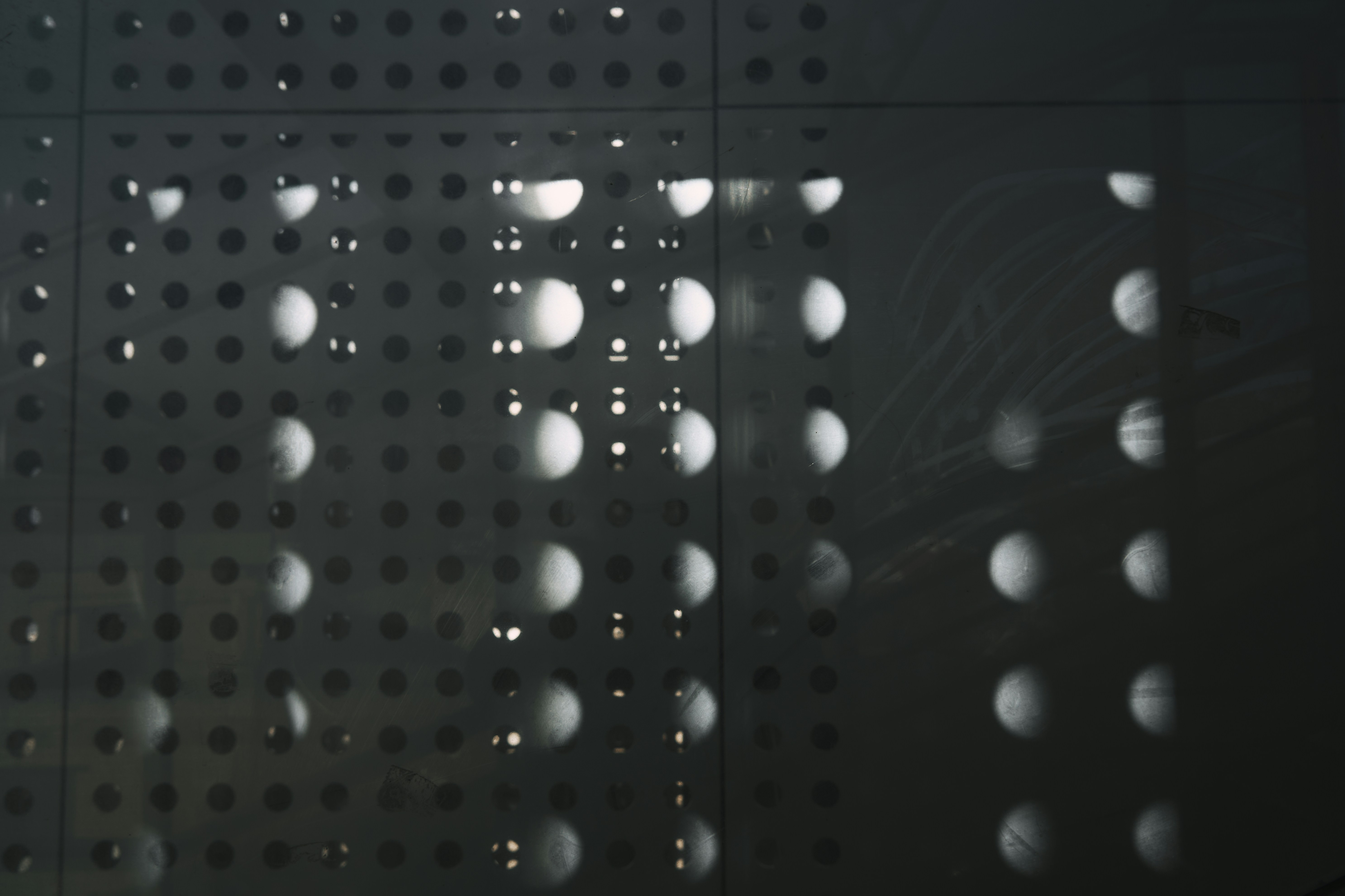 Motif abstrait de cercles et de points sur fond sombre.
