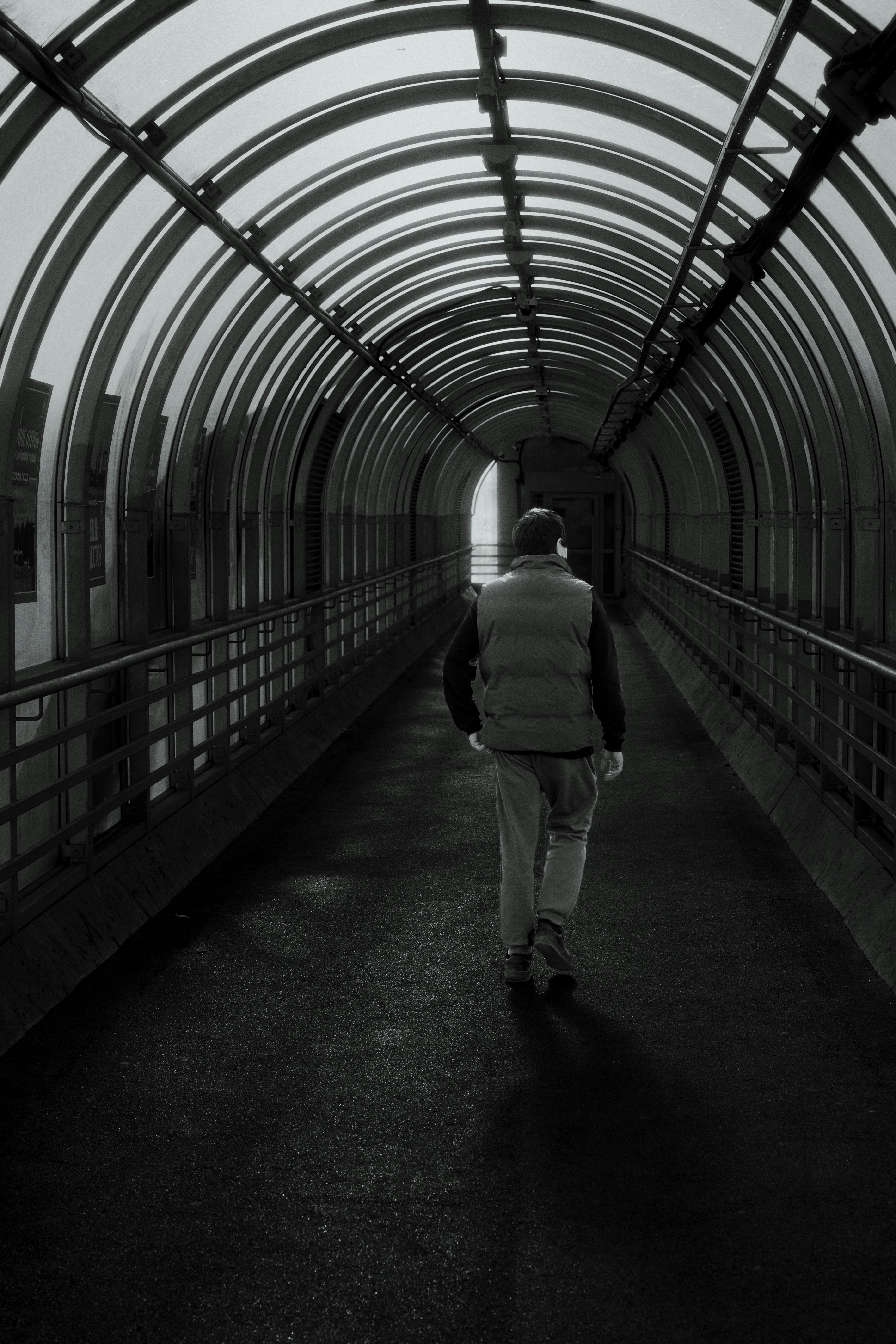Un homme marchant dans une passerelle moderne couverte