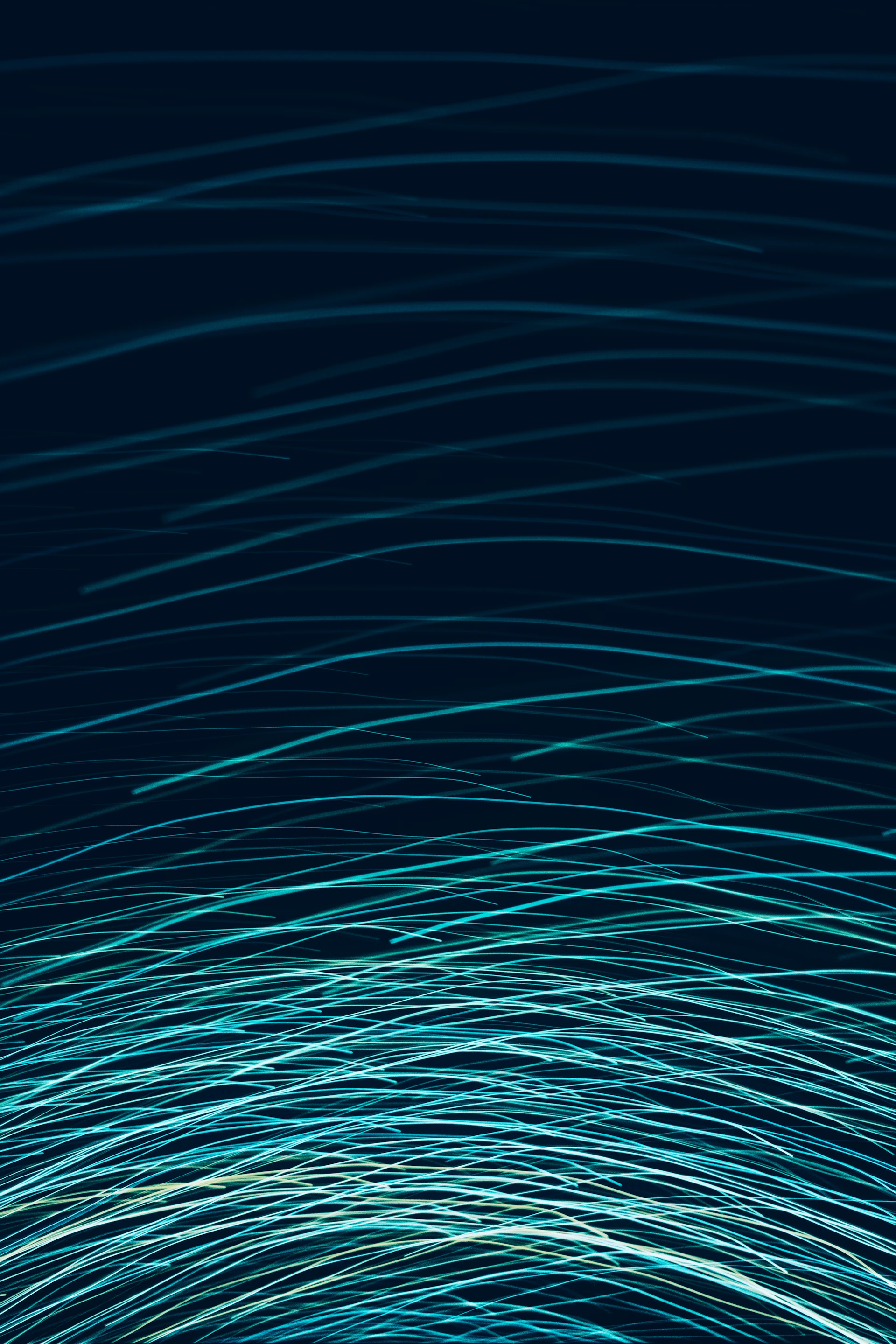 Abstract blue and teal light streaks on dark background