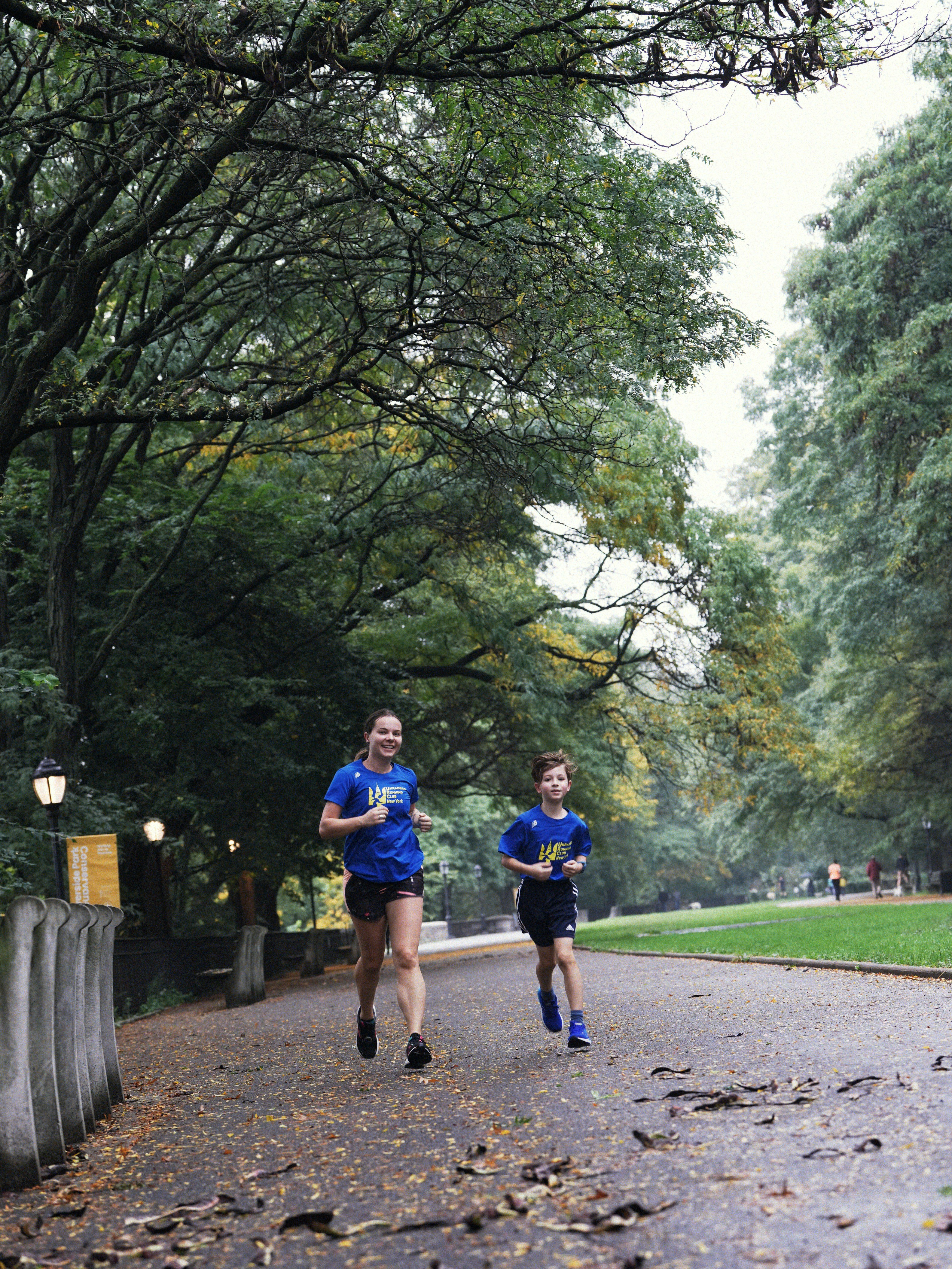 Woman and boy running on park path
