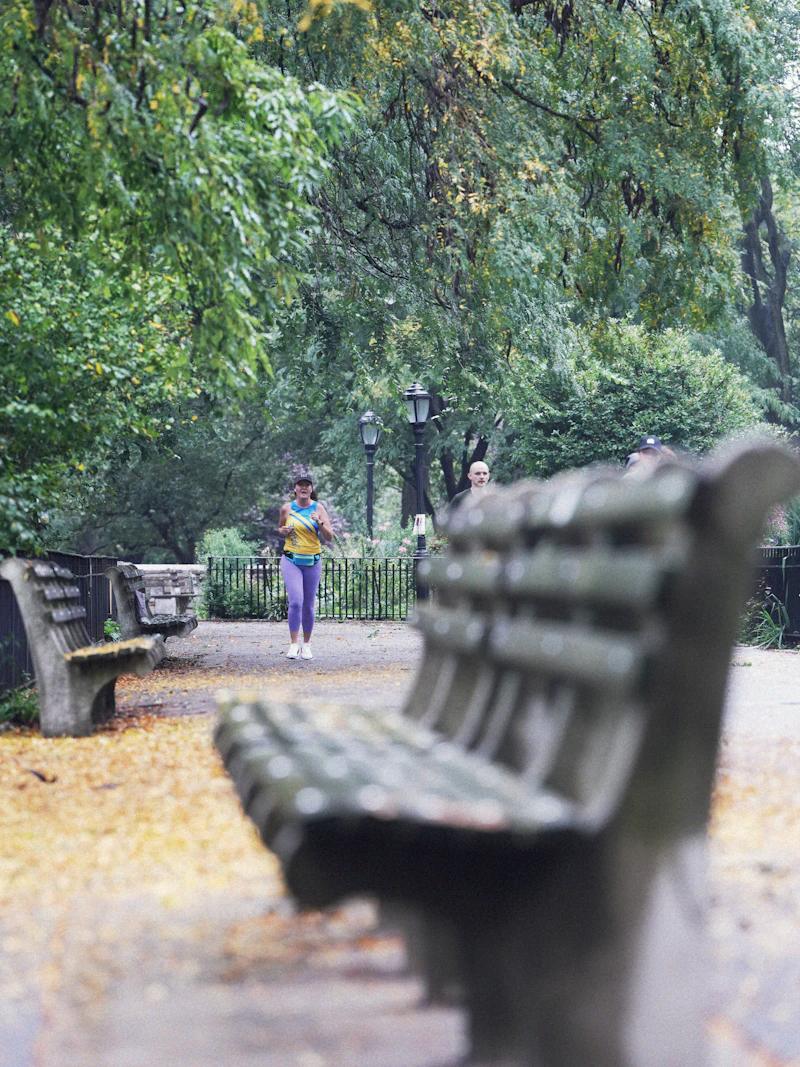 A woman in her forties jogging at an easy pace through a park