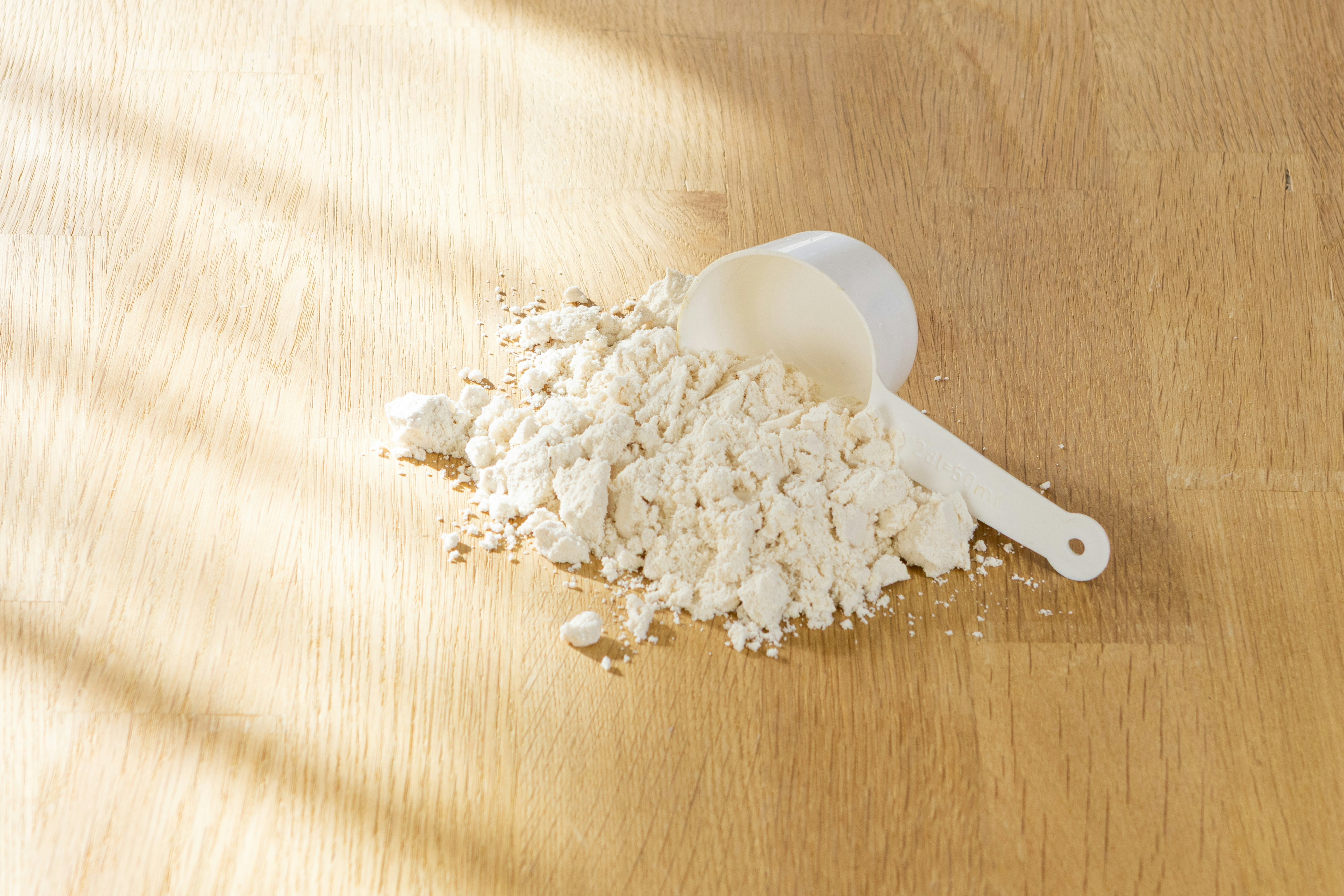 Una cuchara de polvo de proteína lista para un batido post-entrenamiento