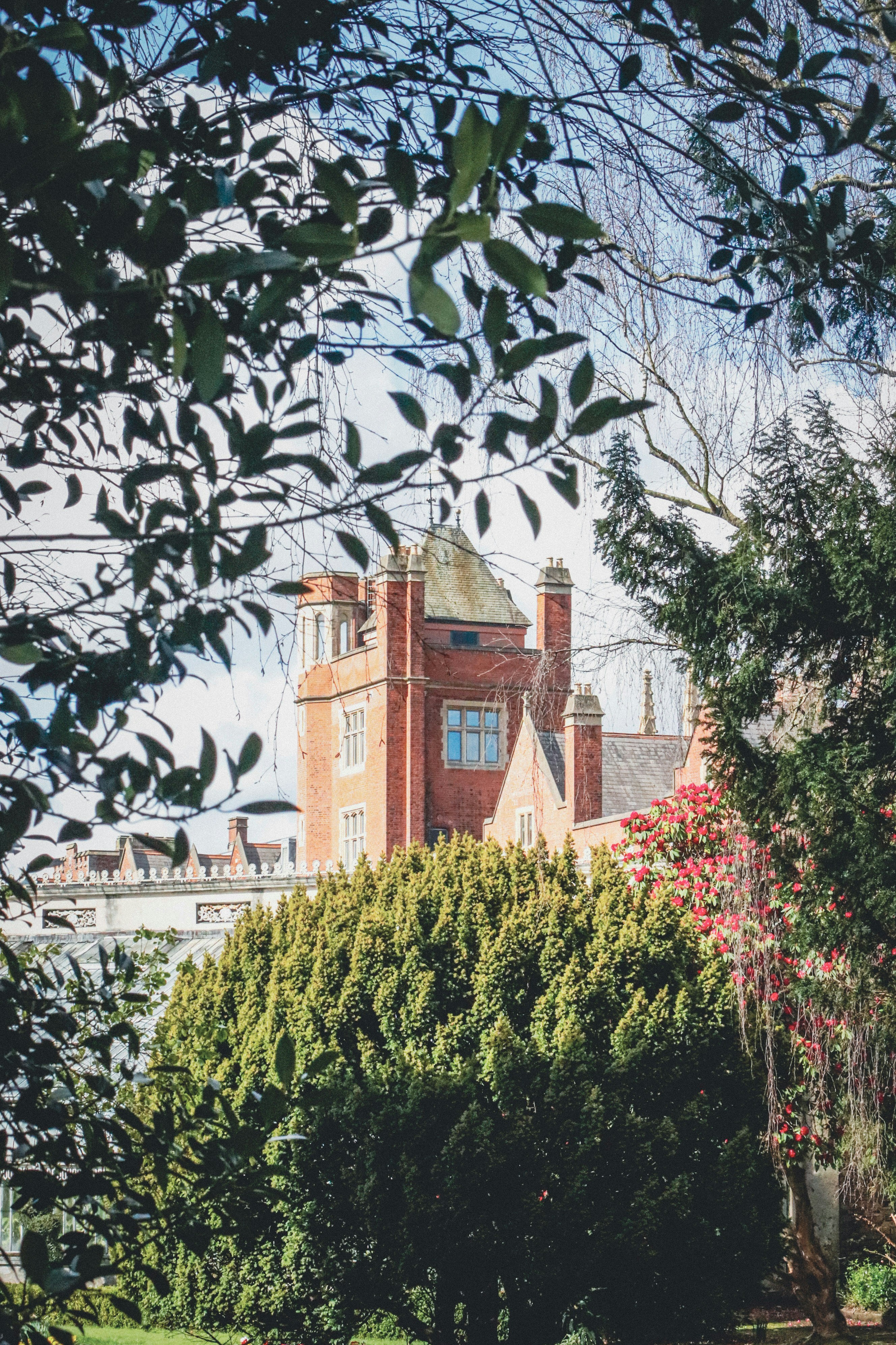緑豊かな木々に囲まれた歴史的なレンガ造りの建物