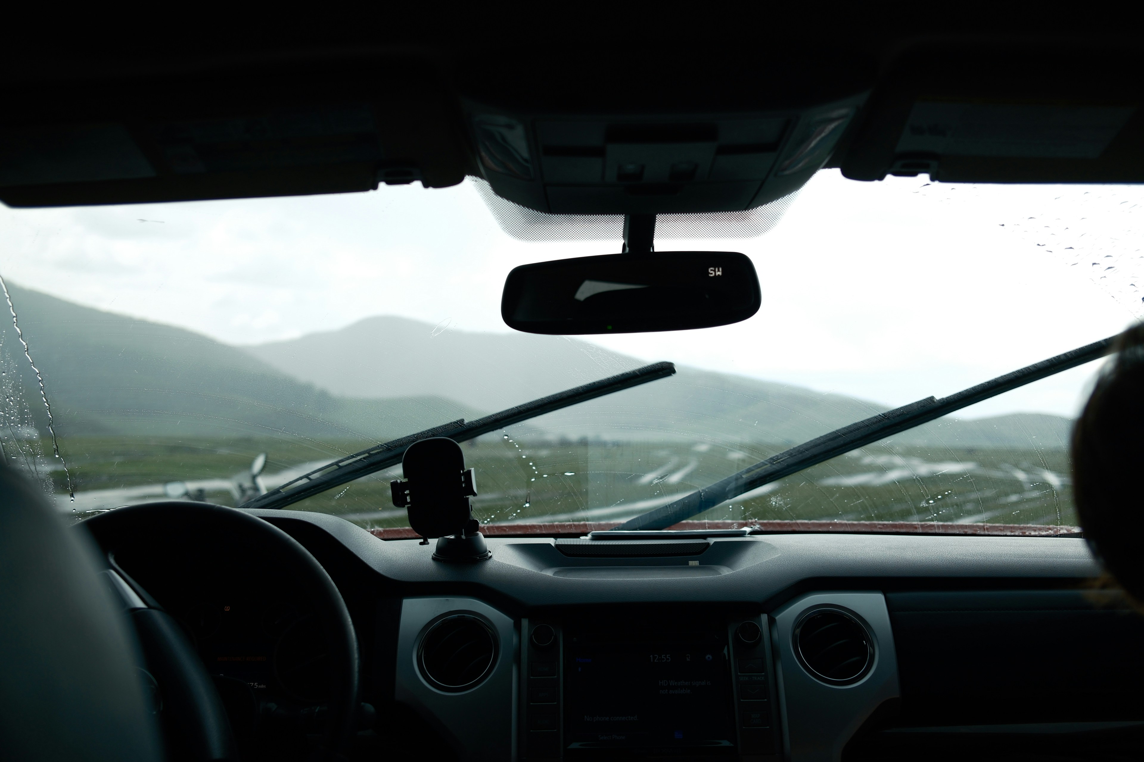 Driving through mountains with rain on windshield