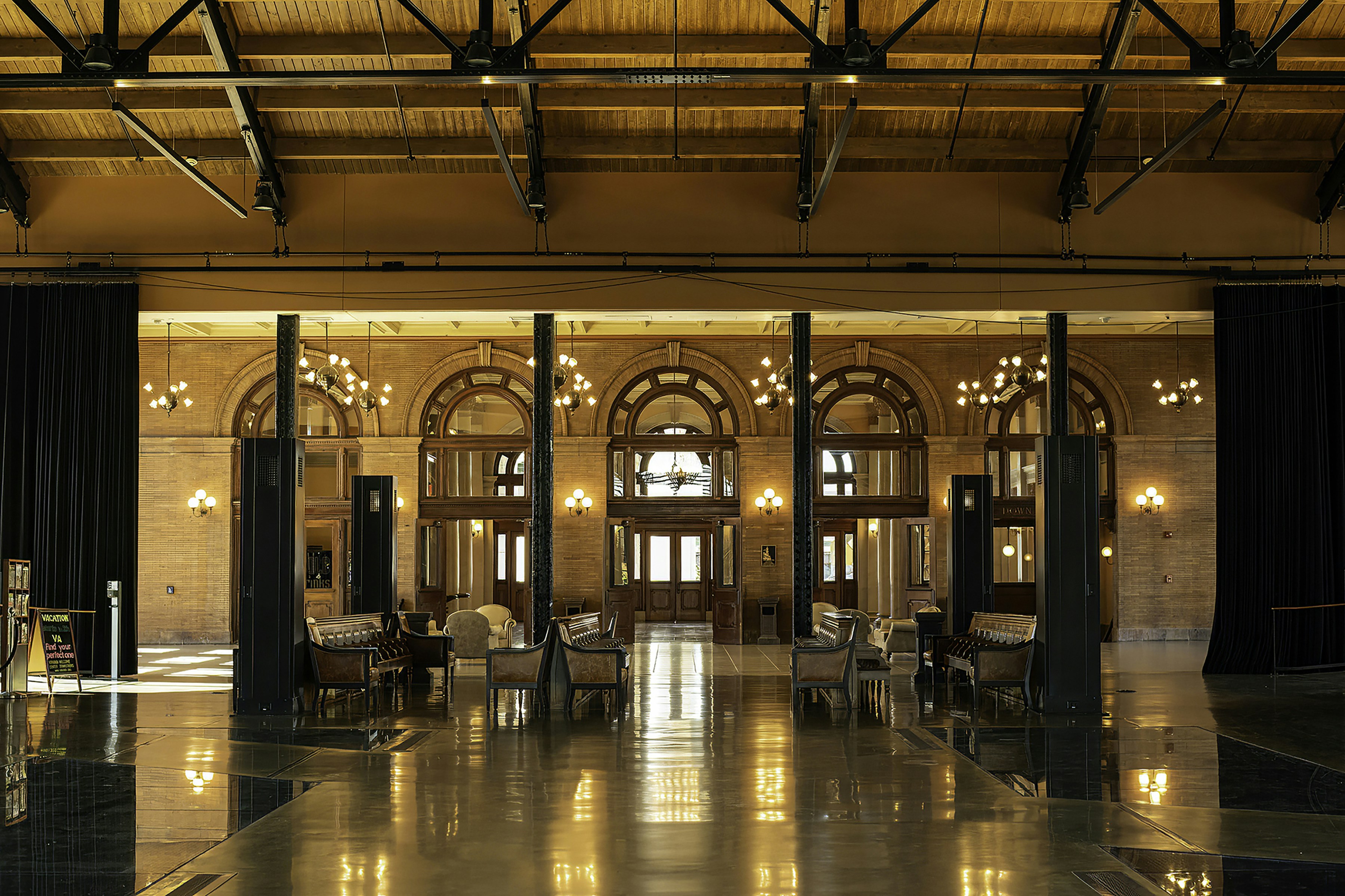 Grand hall with arched windows and chandeliers