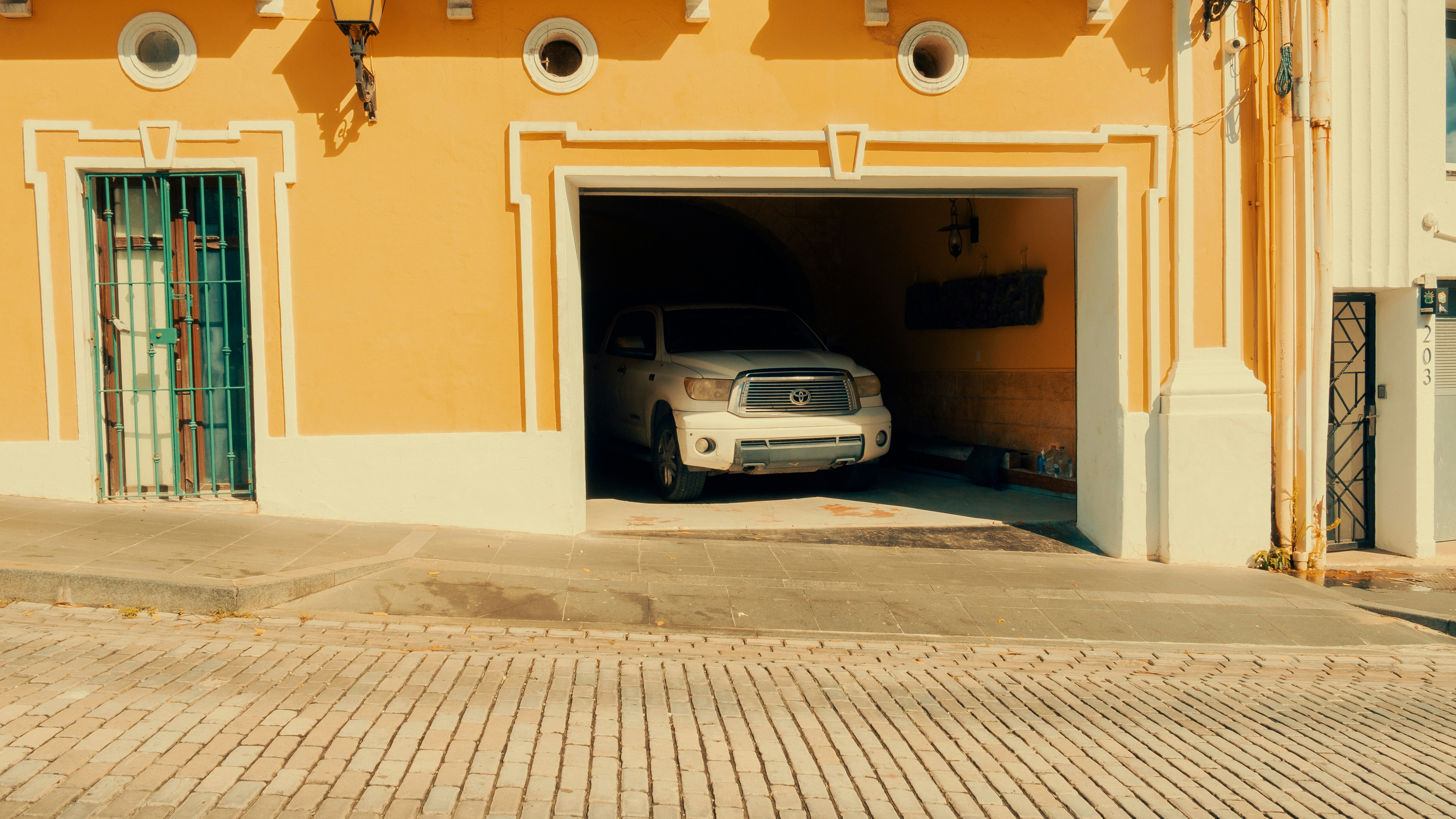 White truck parked in a yellow garage.