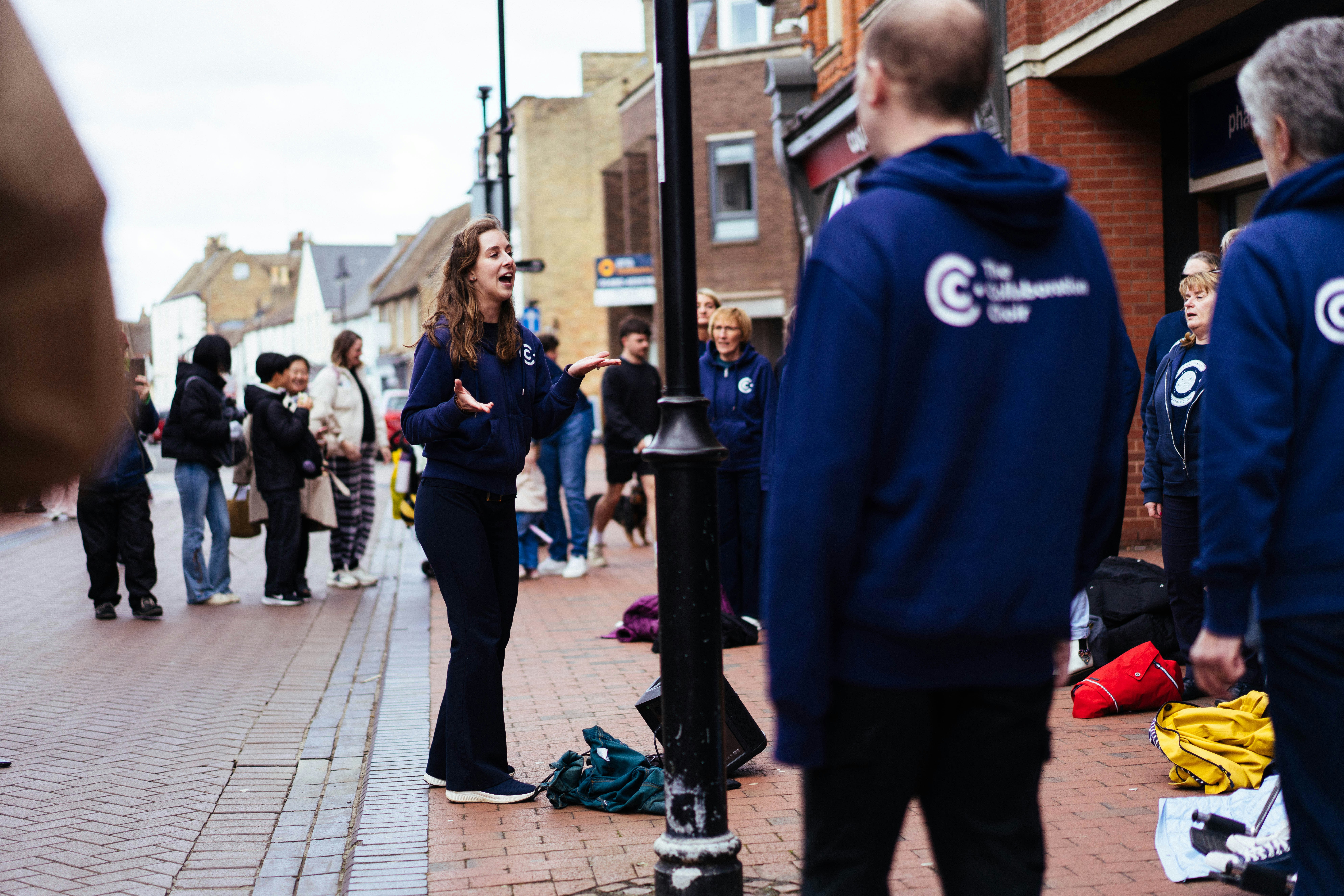 Woman in navy jacket speaking to a group
