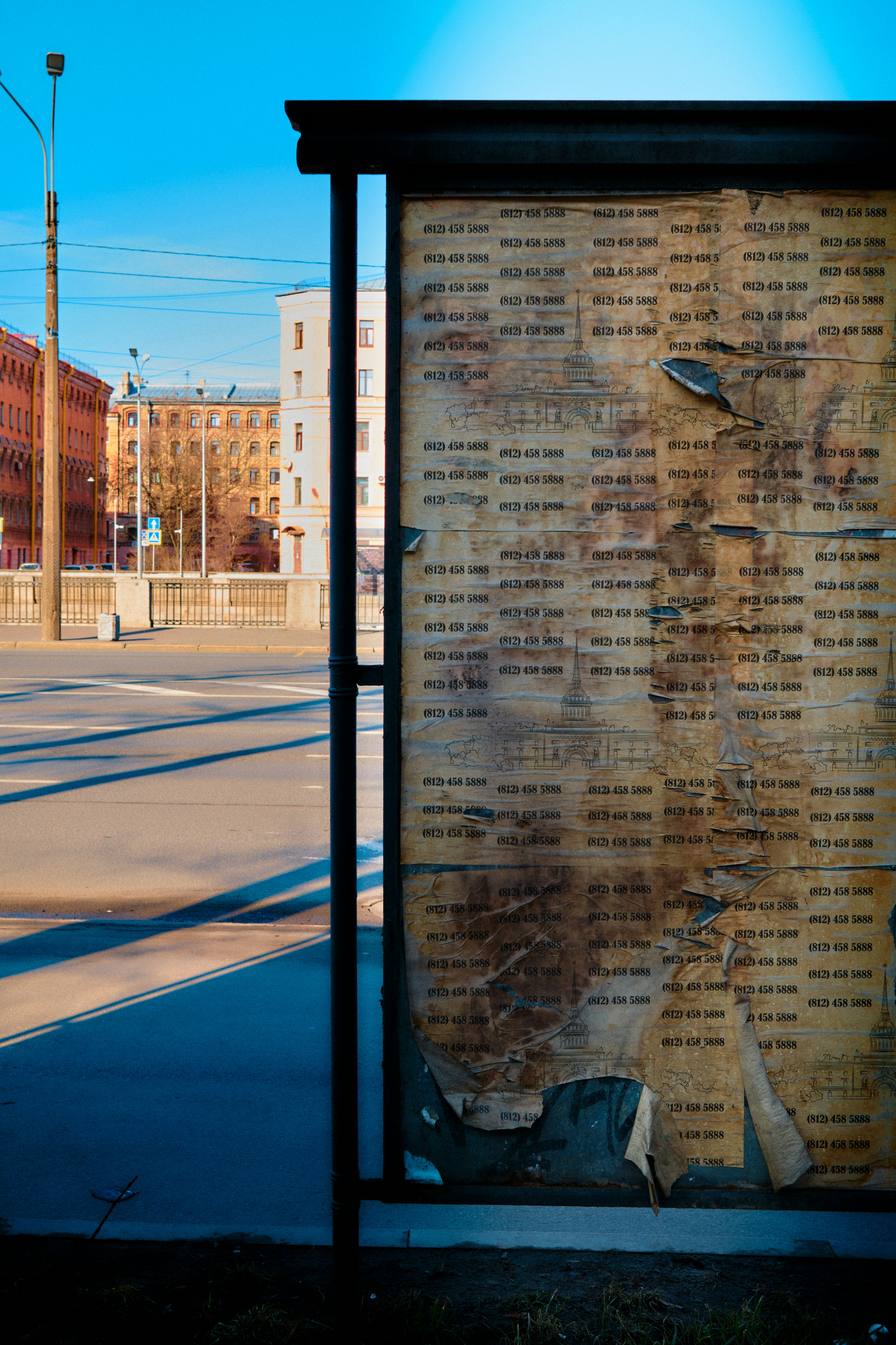 Old bulletin board with torn paper in urban setting