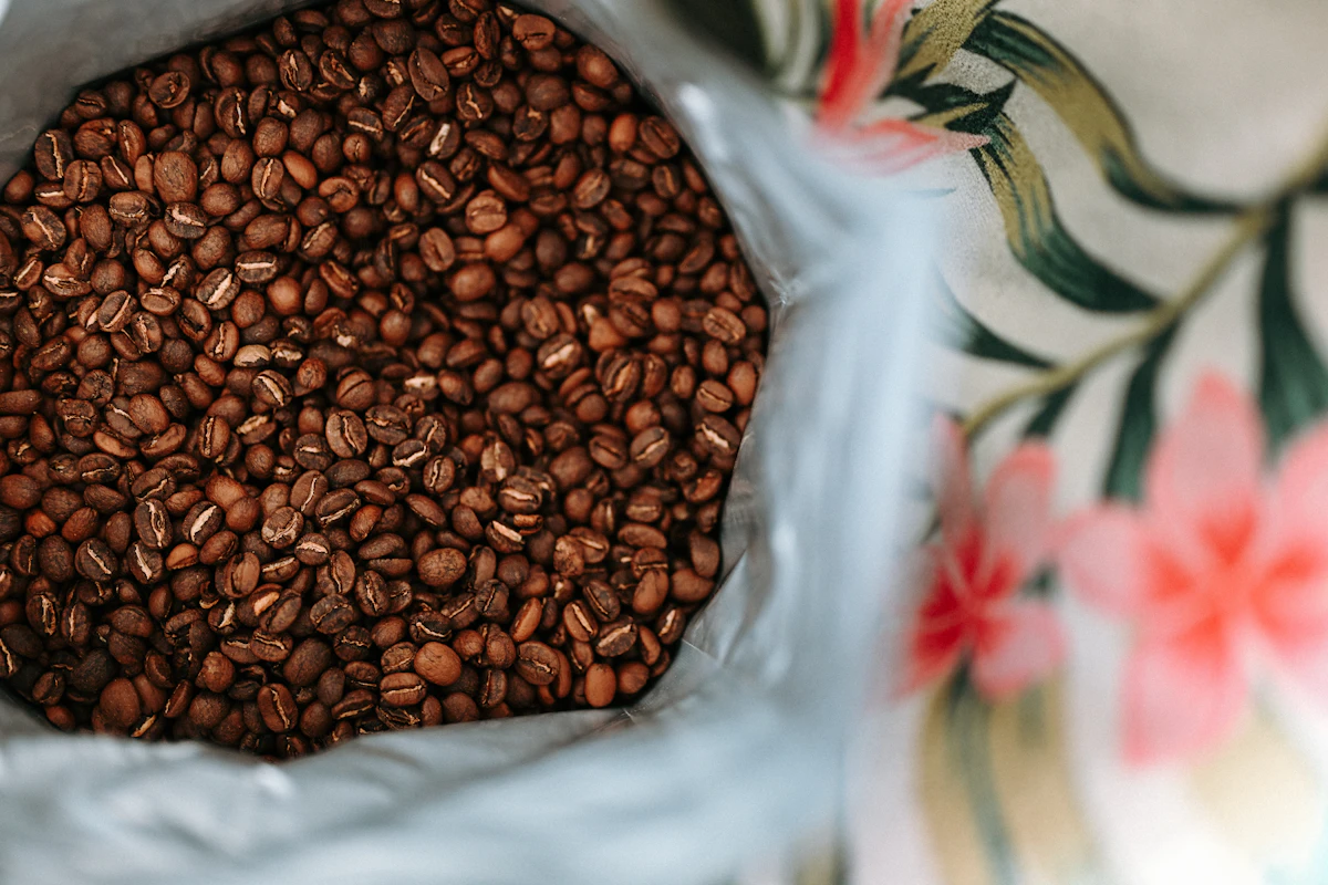 Frisch geröstete Kaffeebohnen, die aus einer Papiertüte rieseln