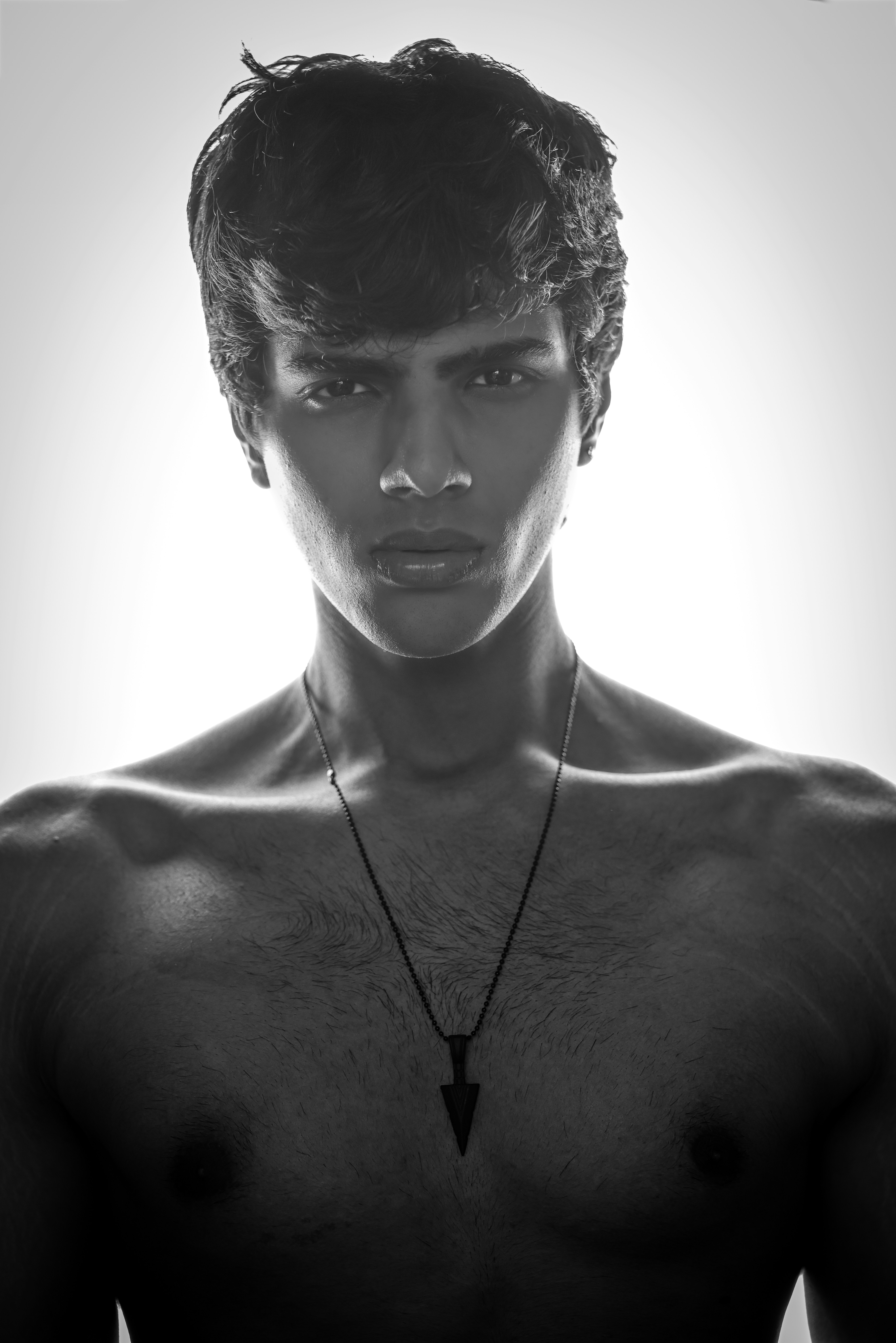 Man with necklace against bright background