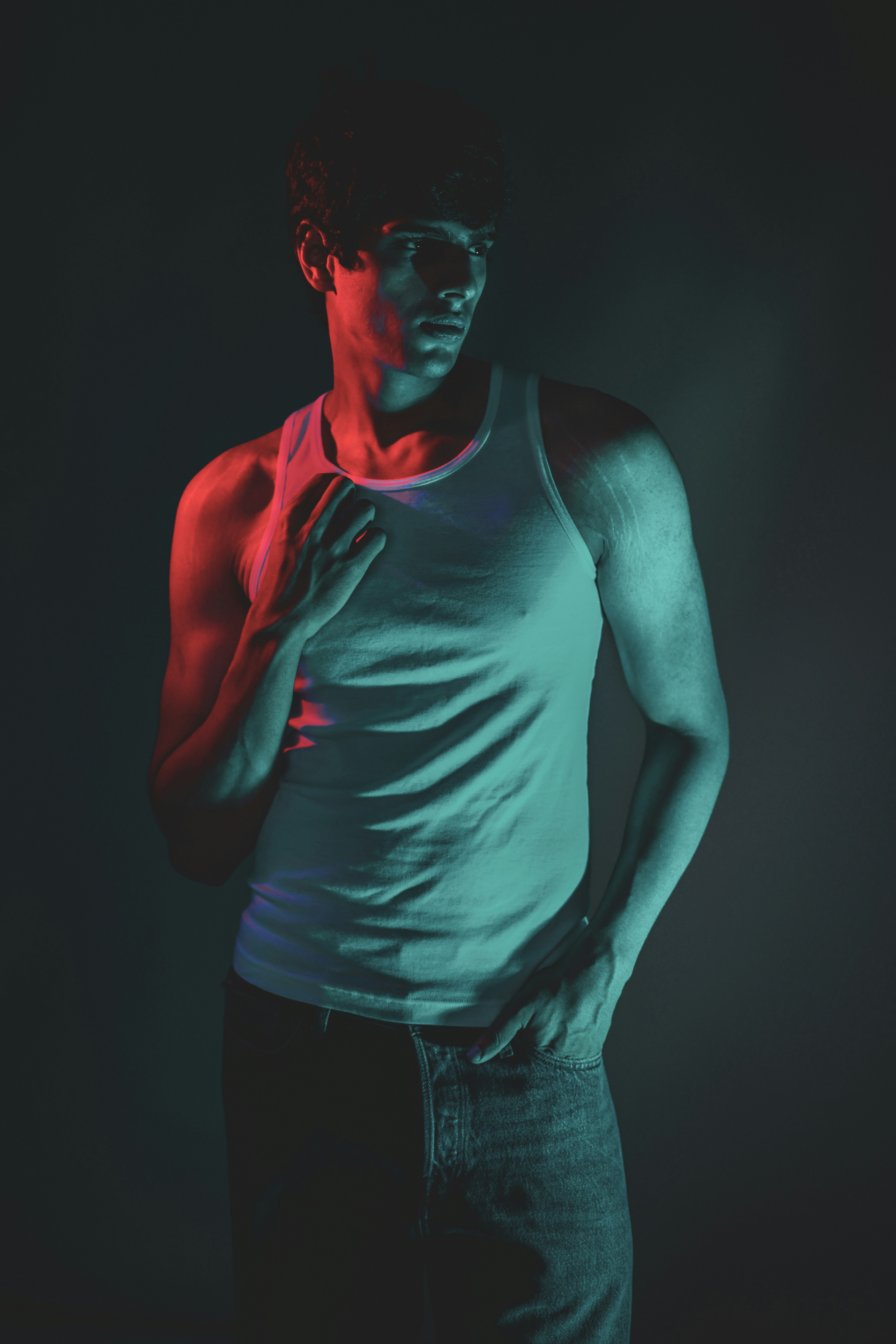 Man in a white tank top with colorful lighting