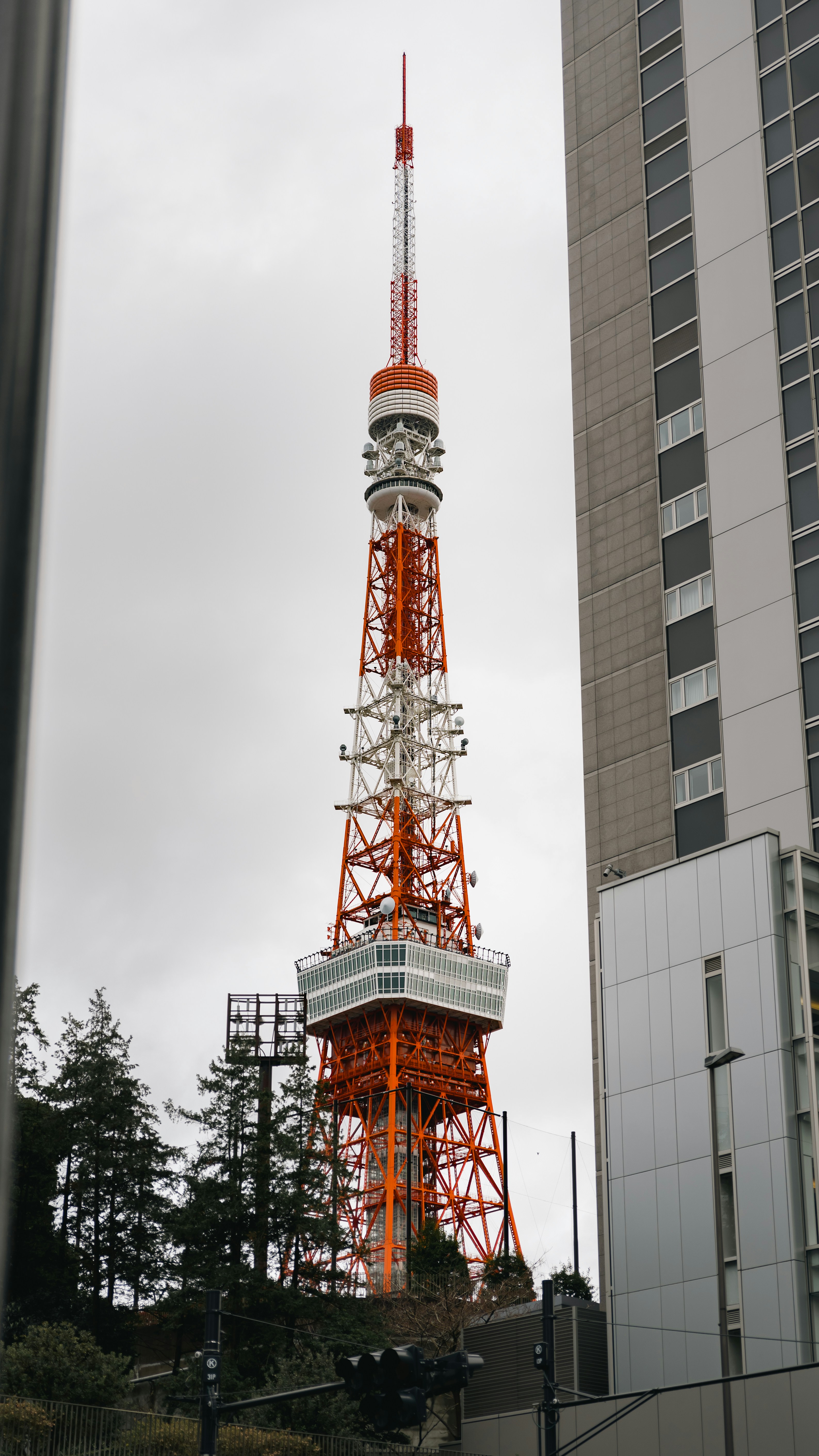 Red and white tower amidst buildings and trees