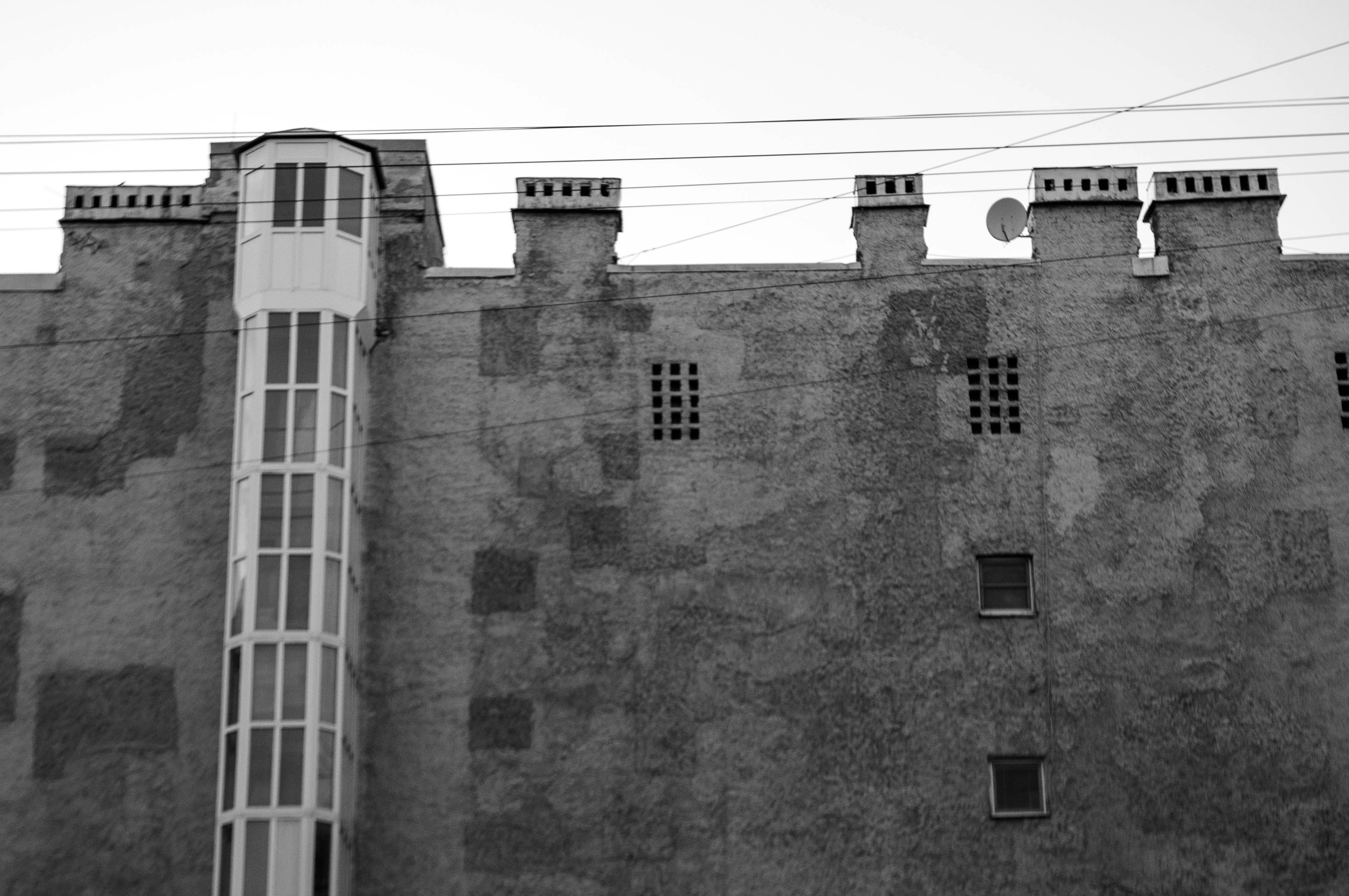 Old building facade with a glass elevator shaft.