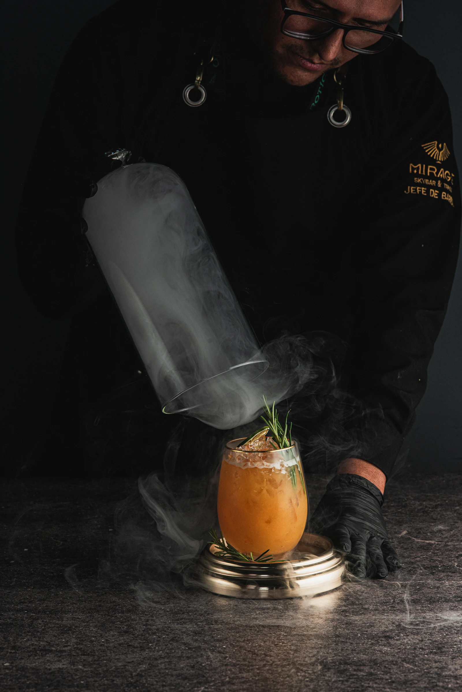 Bartender infusing a cocktail with smoke and Indian herbs