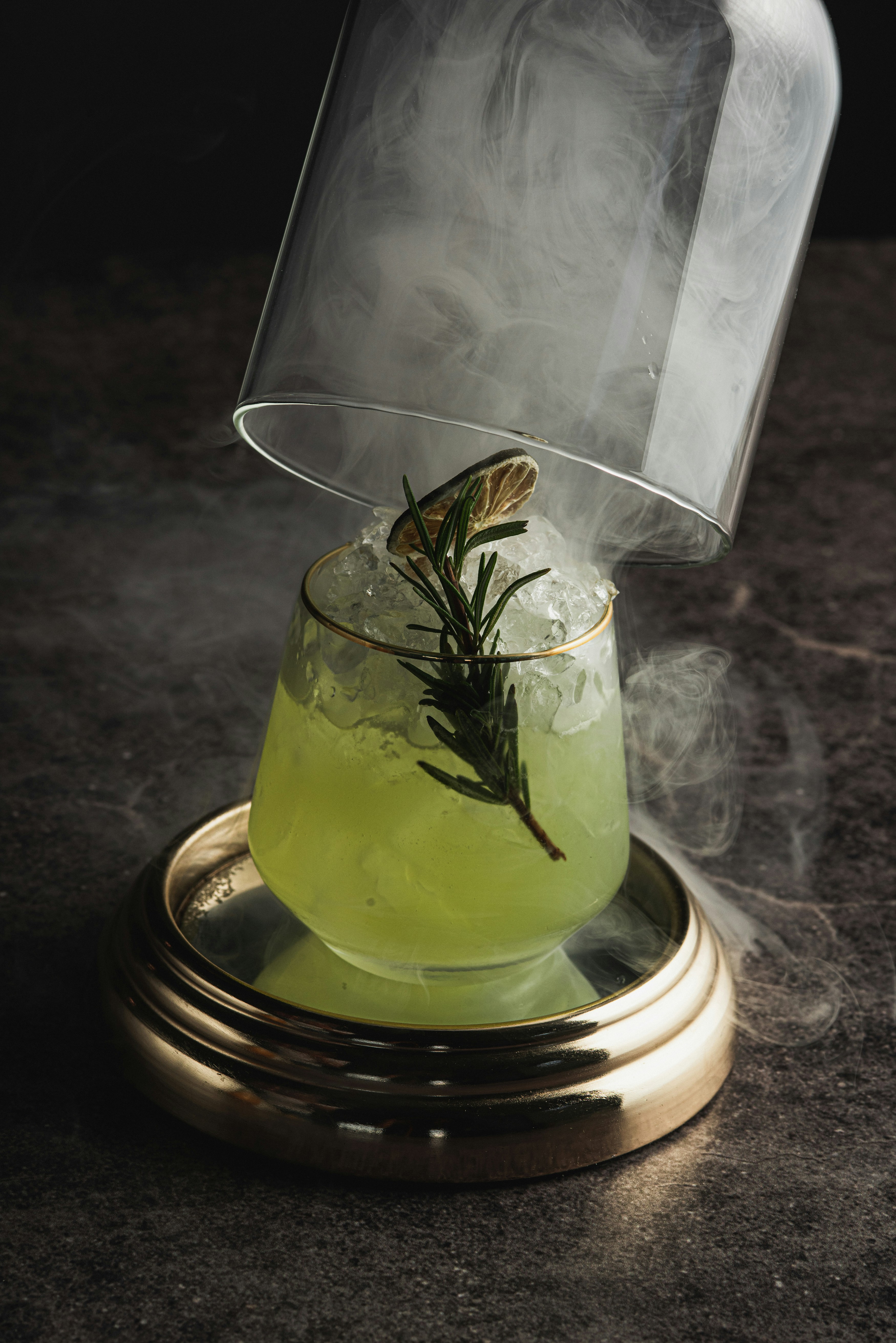 Un cocktail verde con rosmarino e affumico