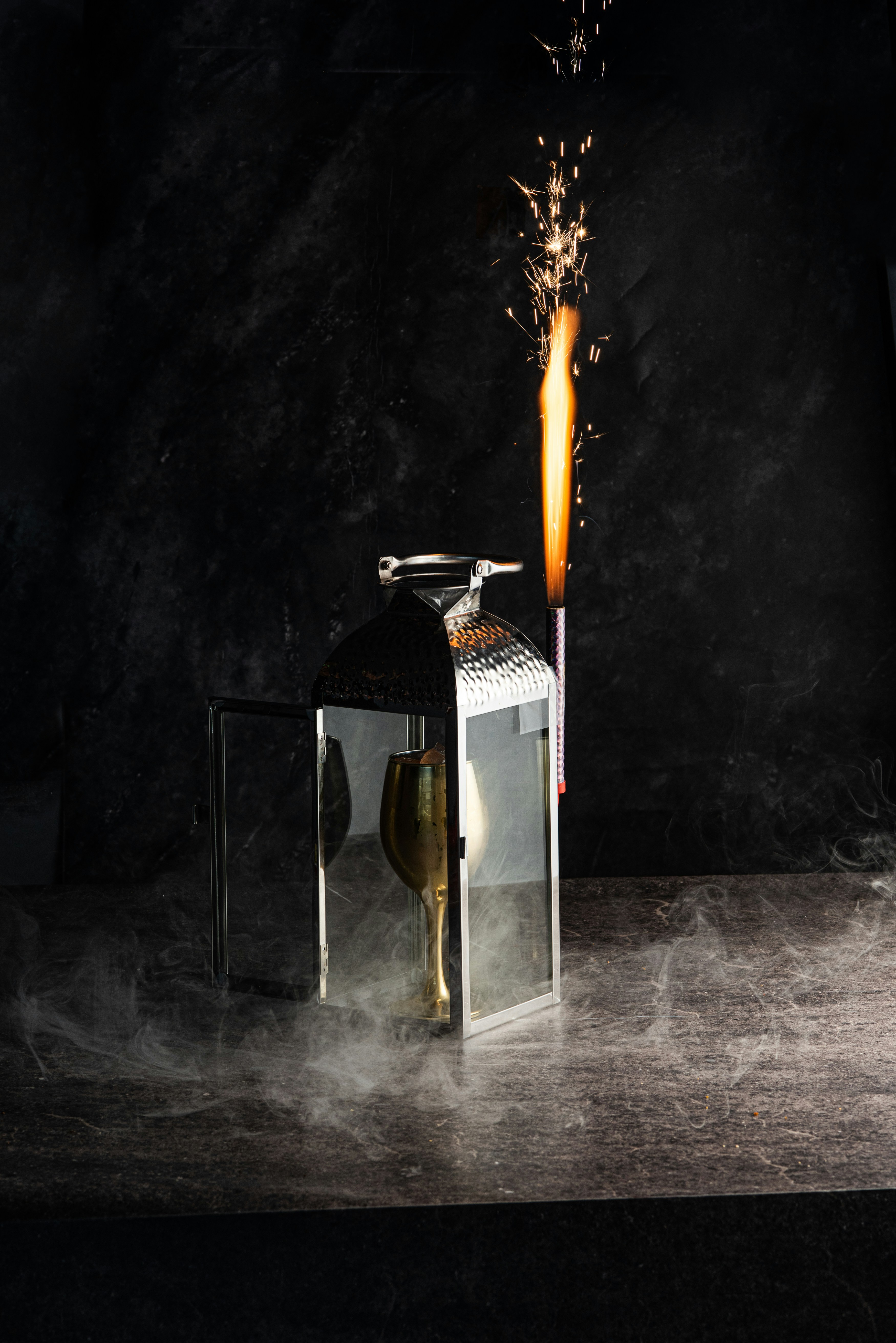 Una lanterna con un bicchiere di champagne e una scintilla