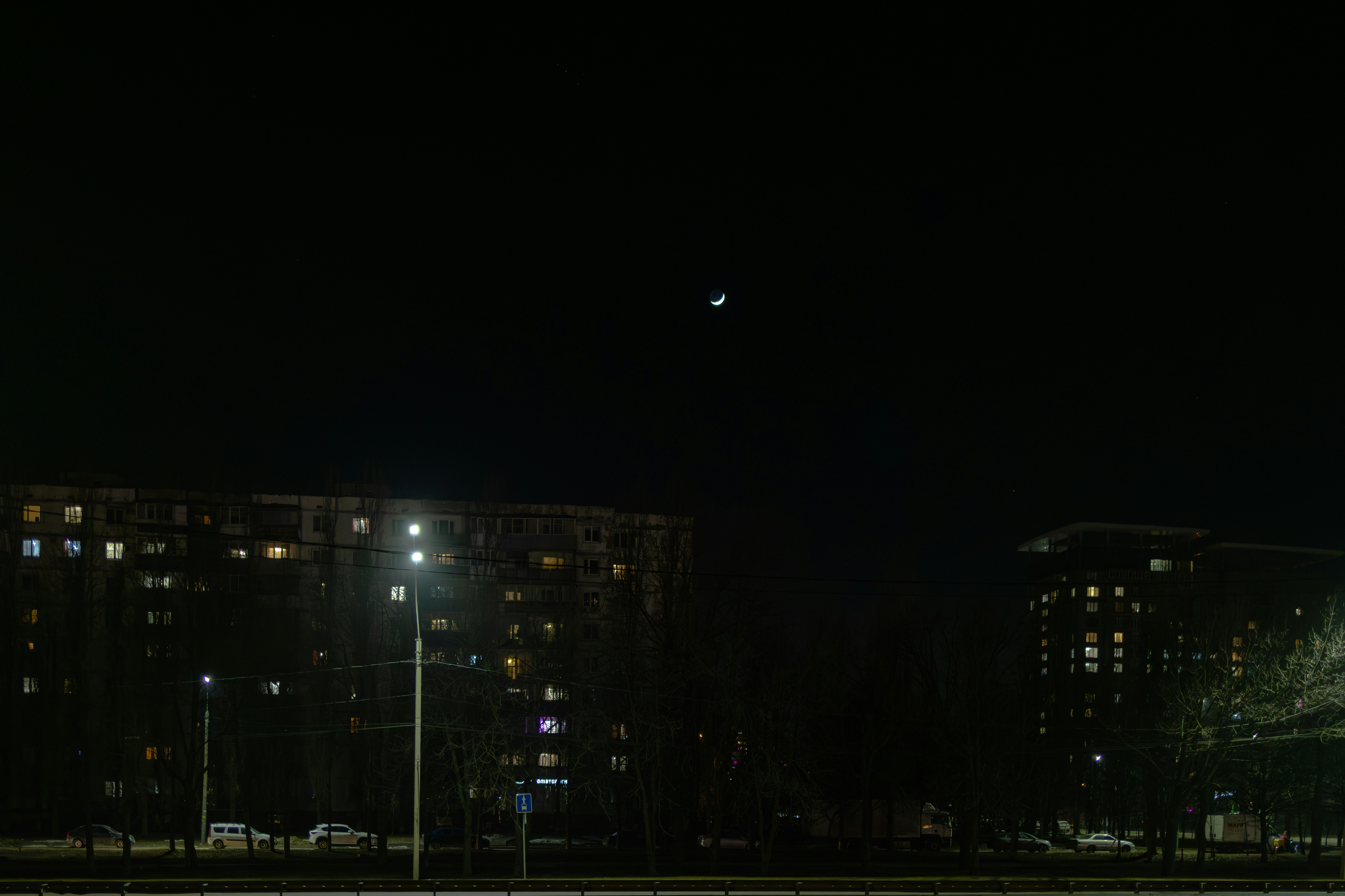 Halbmond über Wohnhäusern in der Nacht