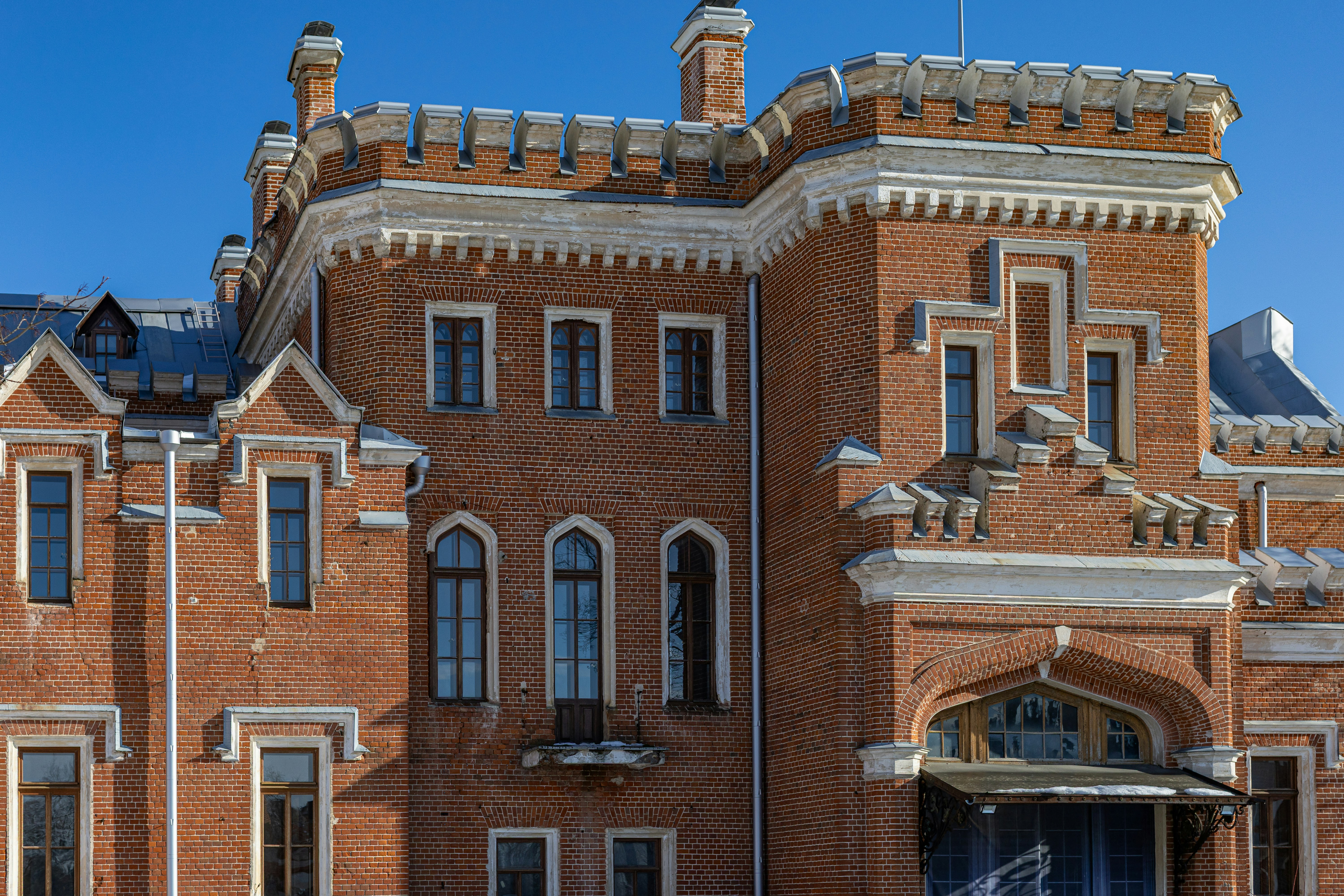 Verziertes Backsteingebäude mit hohen Fenstern und Zinnen