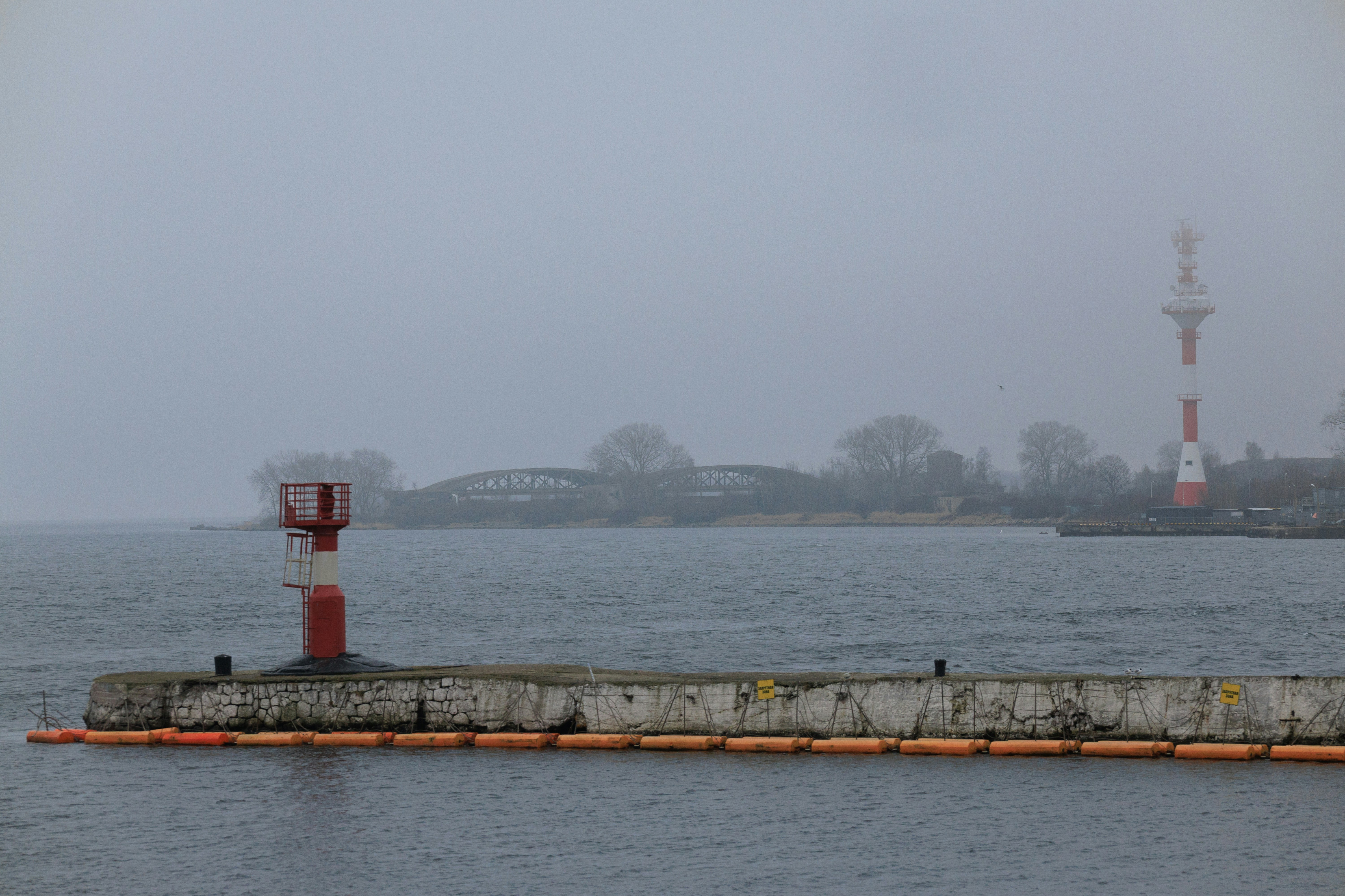 Lighthouse on a pier with a foggy background